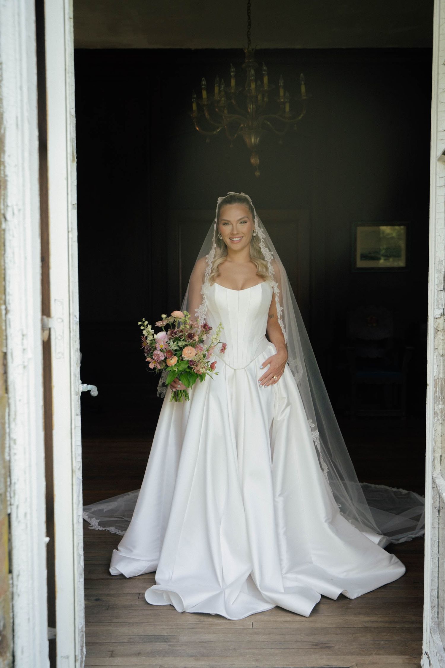 Three bridal portraits in white wedding gowns and veils shown through vintage window frames in moody lighting.
