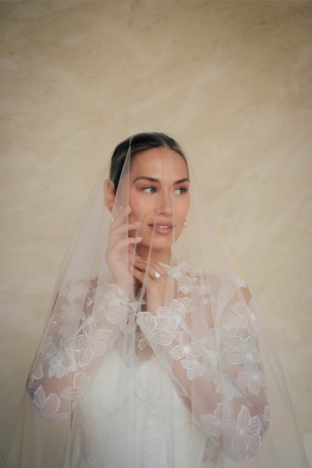 A series of ethereal bridal portraits showing a figure in white lace through delicate sheer veil material.