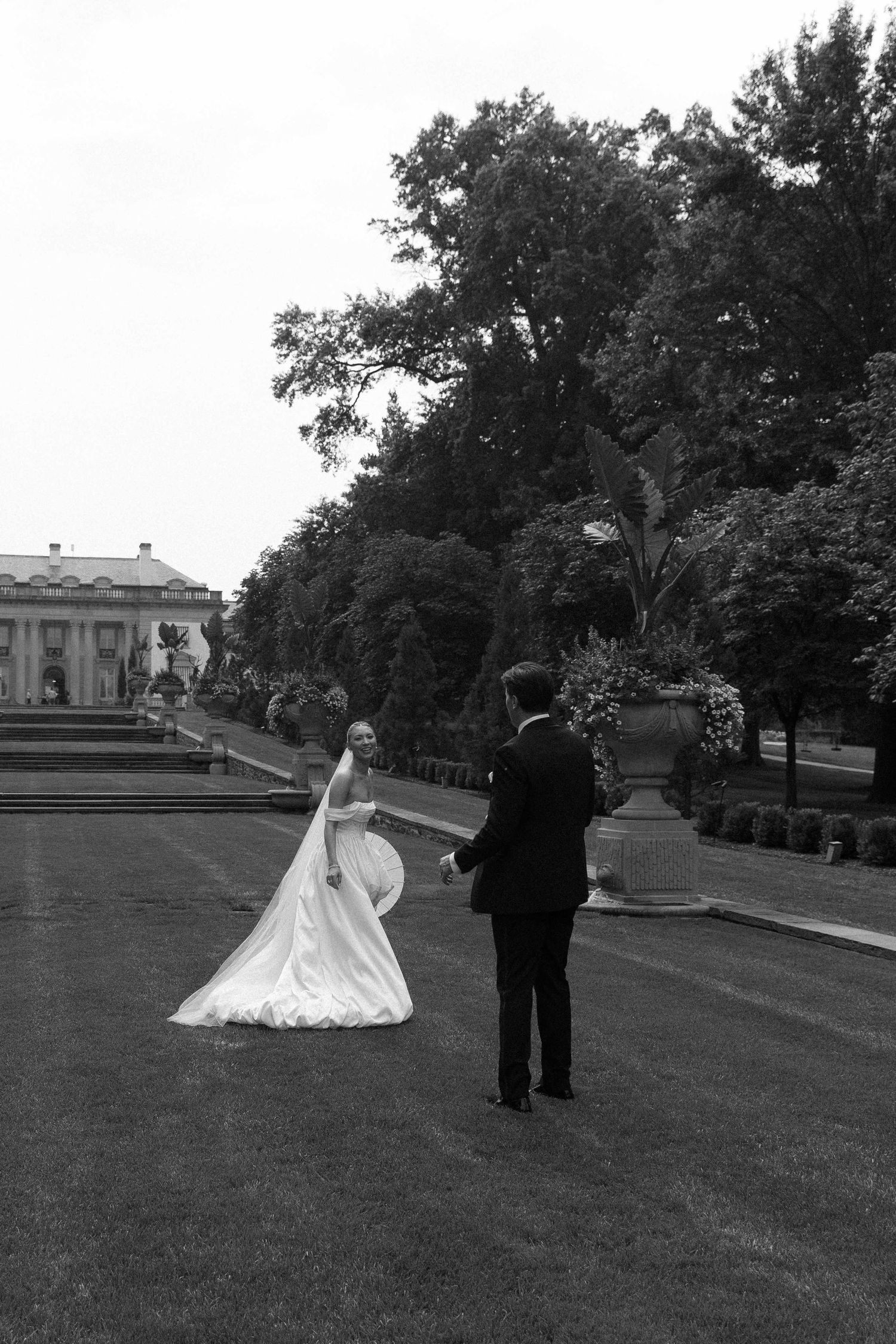 Black and white wedding photography sequence capturing a couple on a grand estate lawn.
