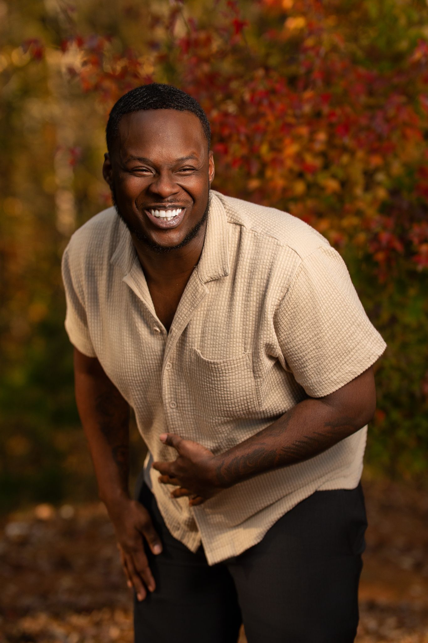 Candid outdoor portrait against autumn foliage wearing beige knit shirt. Powerrpackmedia Houston Texas
