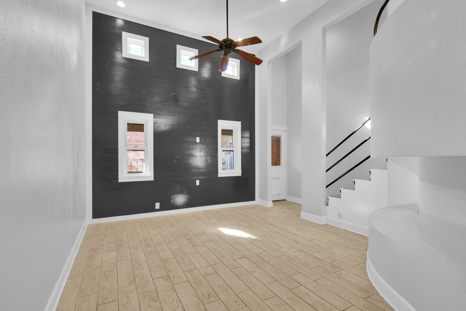 Bright modern home interior with white walls, hardwood floors, and natural light streaming through windows.