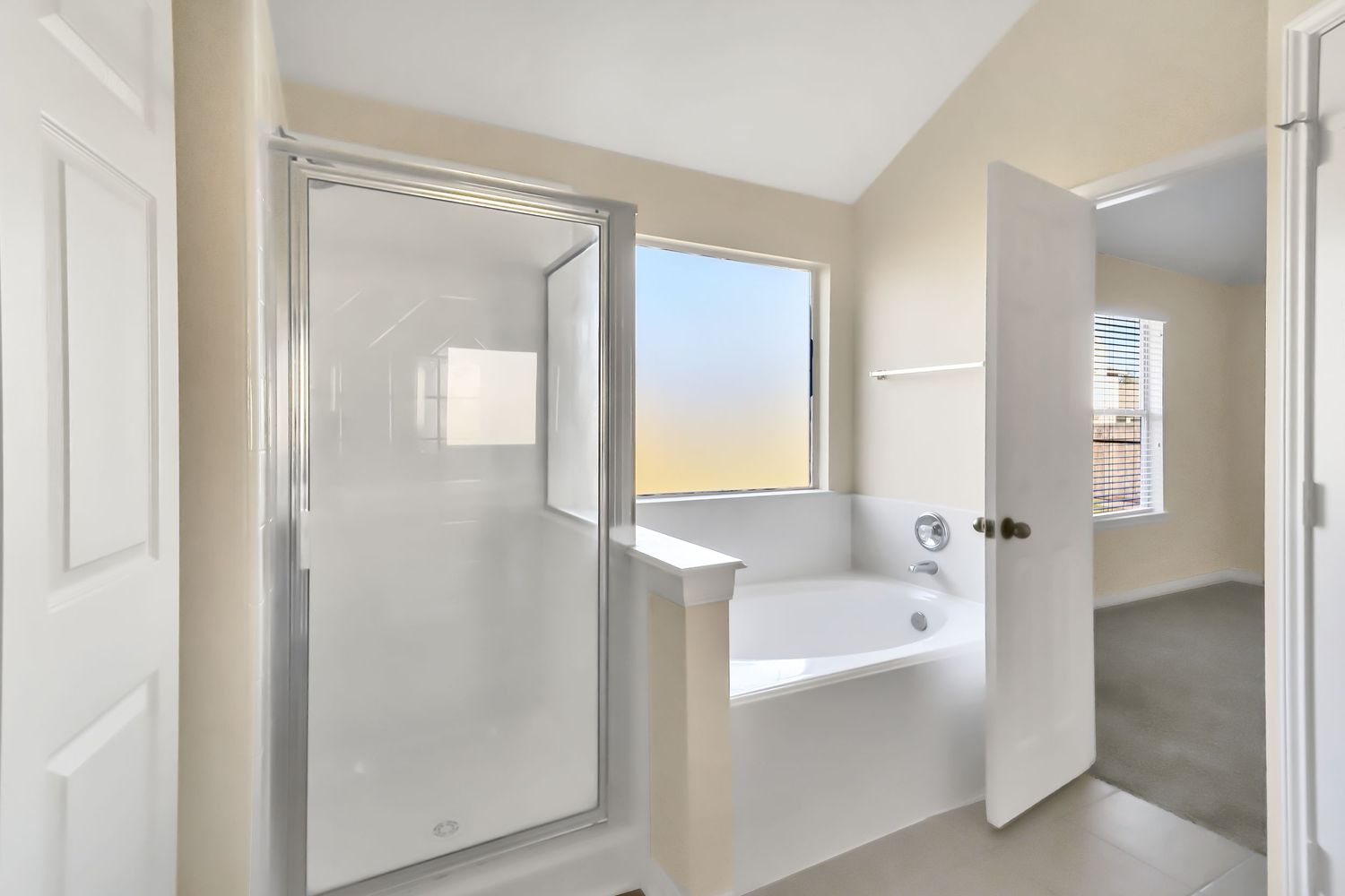 A bright and airy hallway with white doors, beige walls, and modern sconce lighting fixtures along the walls.