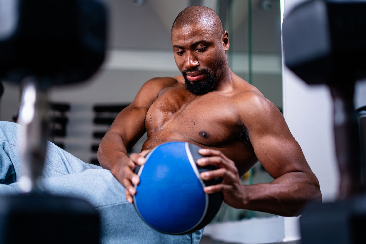 Athletic person exercising with a blue medicine ball in a modern gym setting. Powerrpackmedia Houston Texas