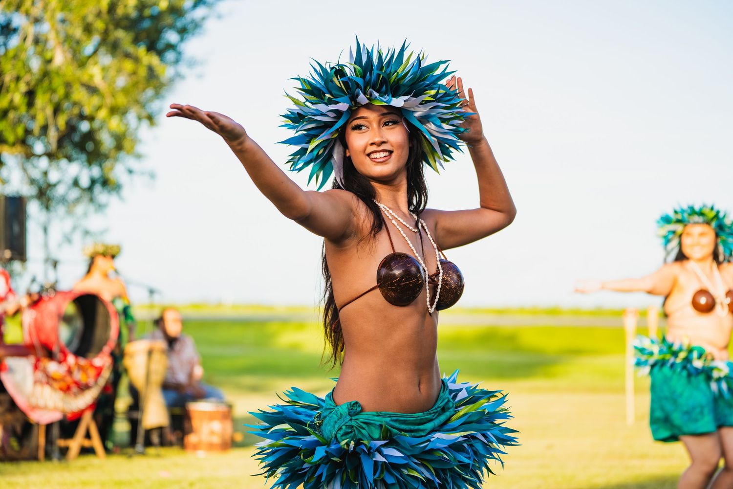 Dancers in blue feathered costumes perform at an outdoor summer festival. Powerrpackmedia Houston Texas