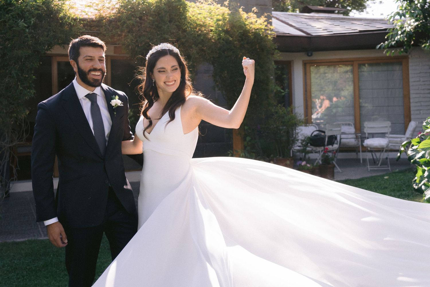 Elegant outdoor wedding ceremony setup with white chairs and floral arrangements at sunset.