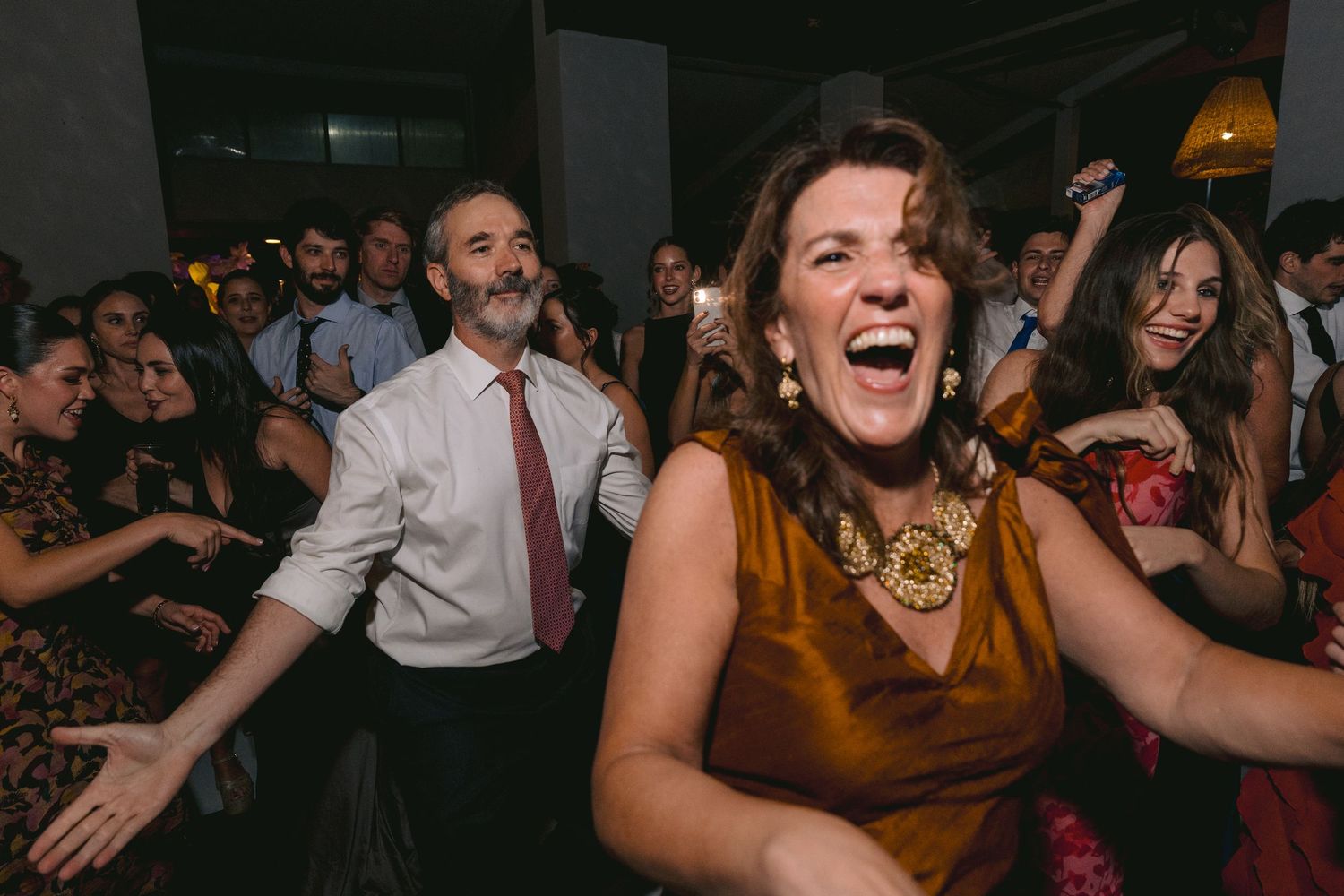 Lively dance floor scene with guests in formal wear enjoying the wedding celebration.