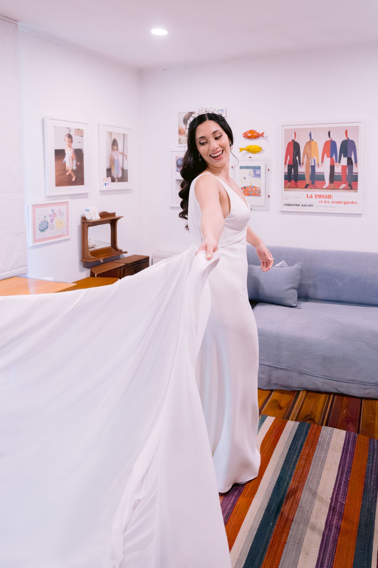 A flowing white wedding dress being showcased in a bright room with colorful floor decor.