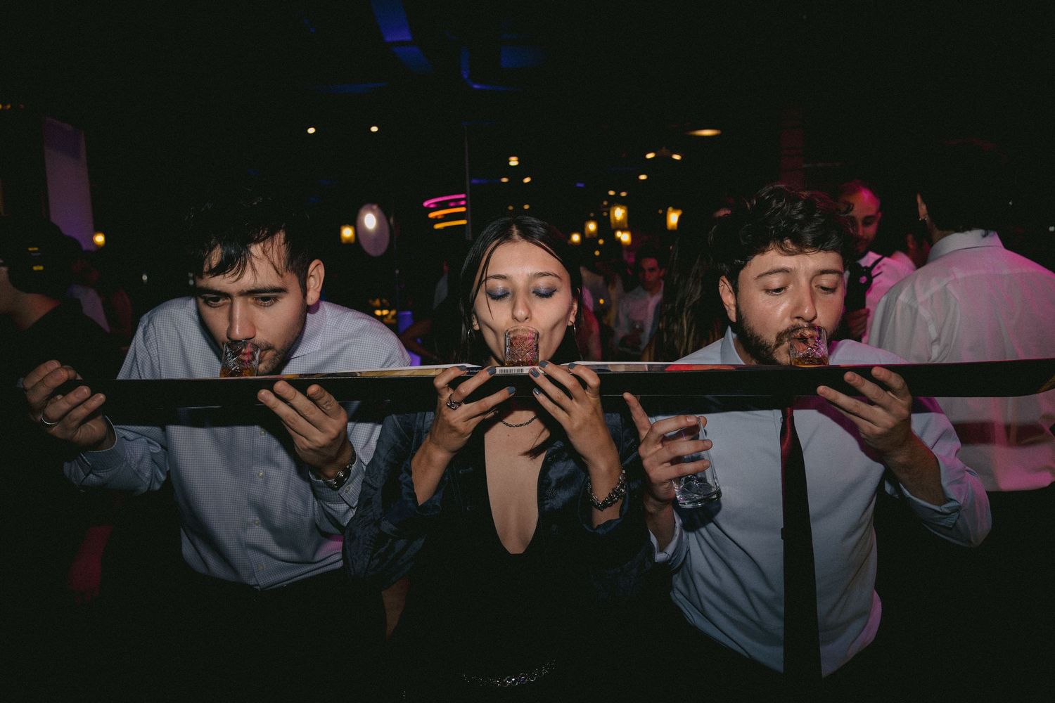 Wedding guests hold up their phones to capture a special moment in low light.