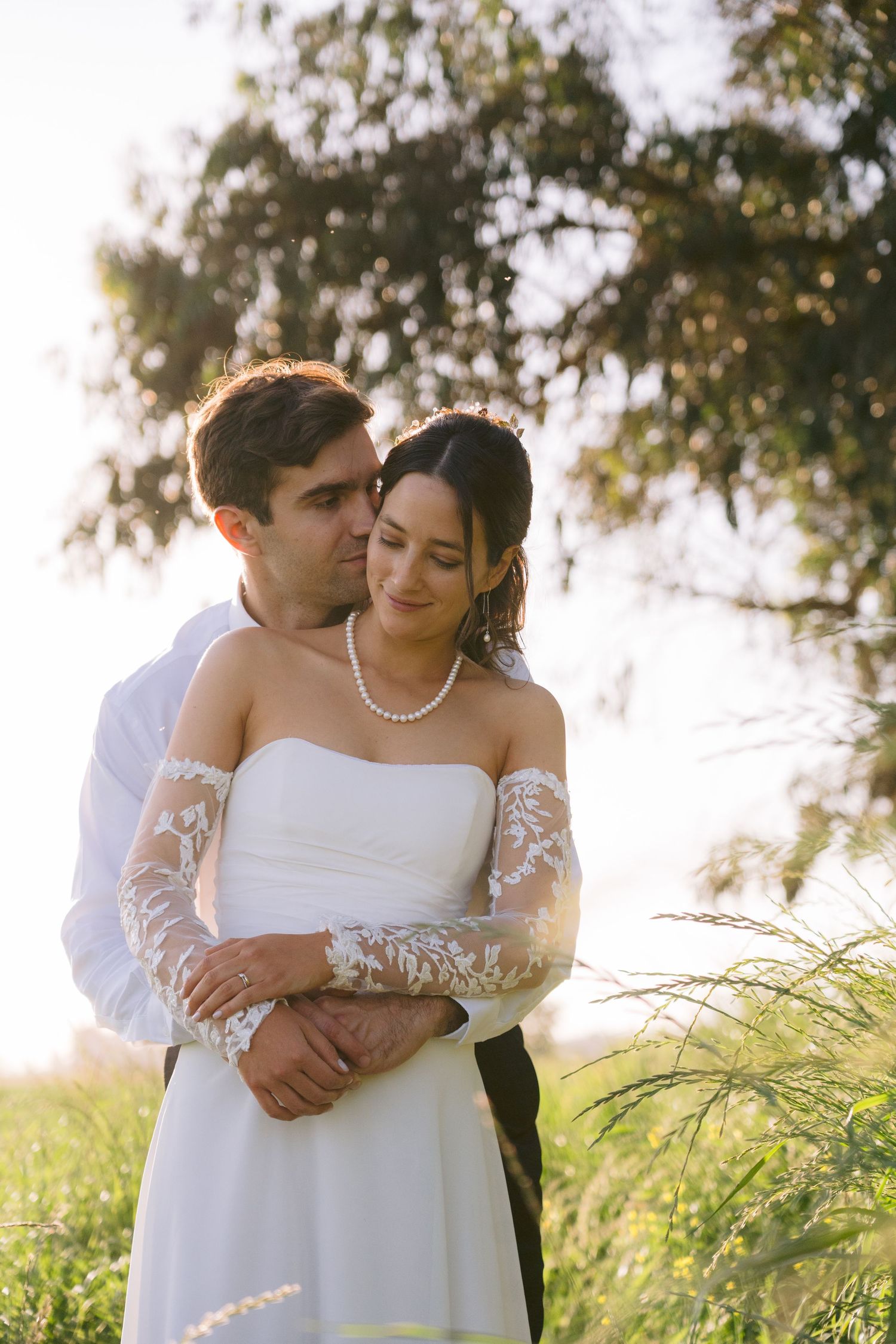 Romantic outdoor wedding portrait in soft natural lighting with tall grass.