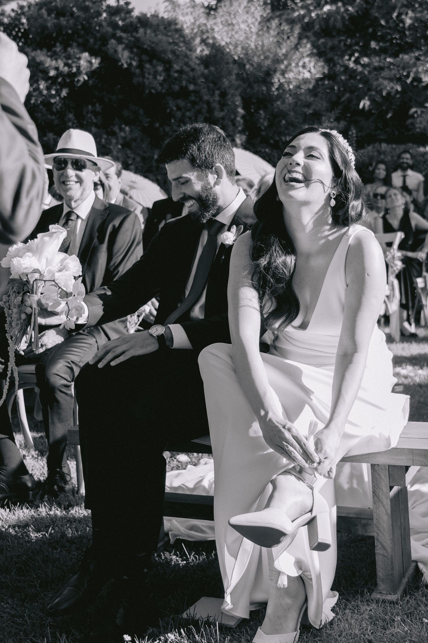 Black and white photo of joyful wedding celebration outdoors with guests.