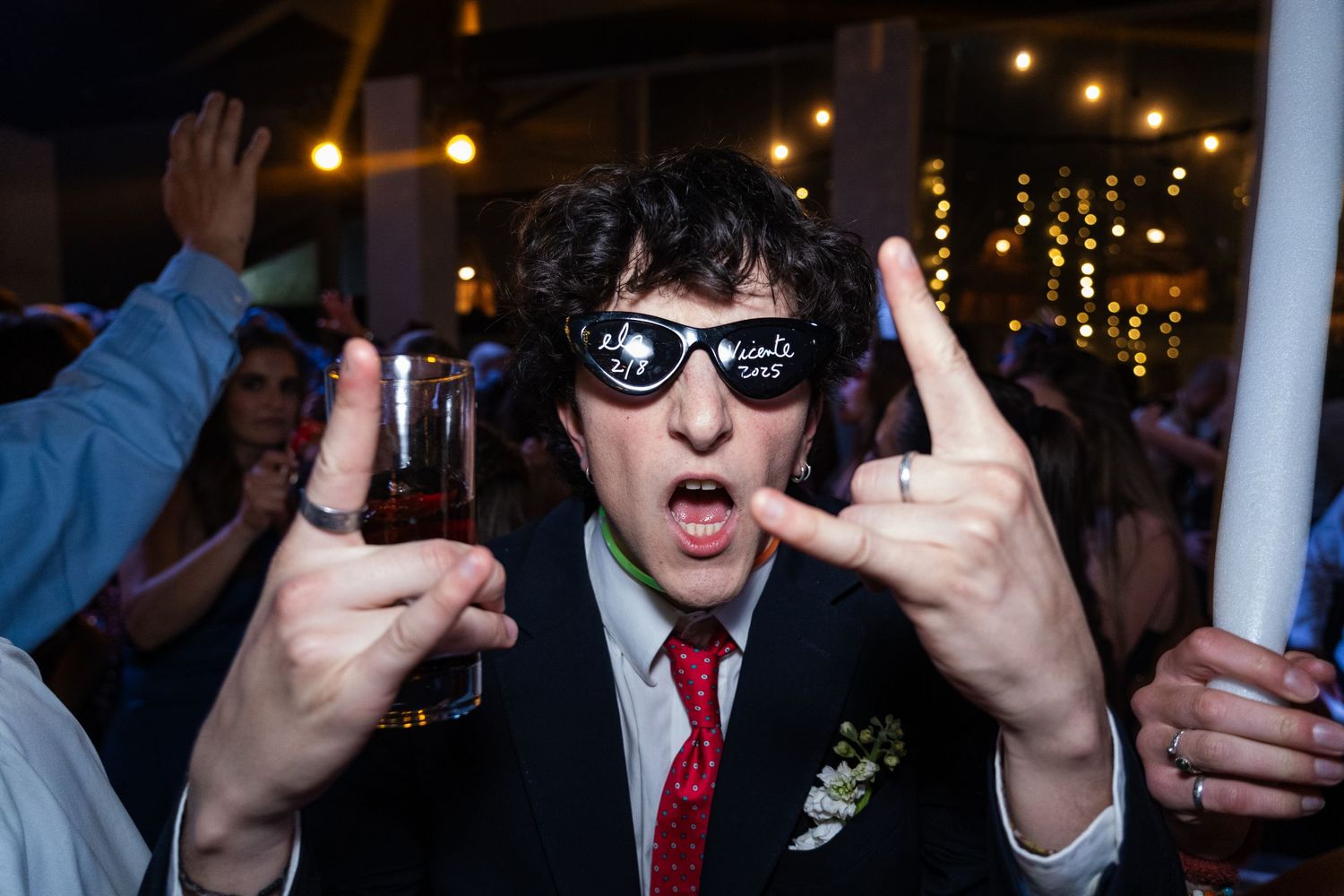 Guests in formal attire enjoying a lively dance party with colorful lighting effects.