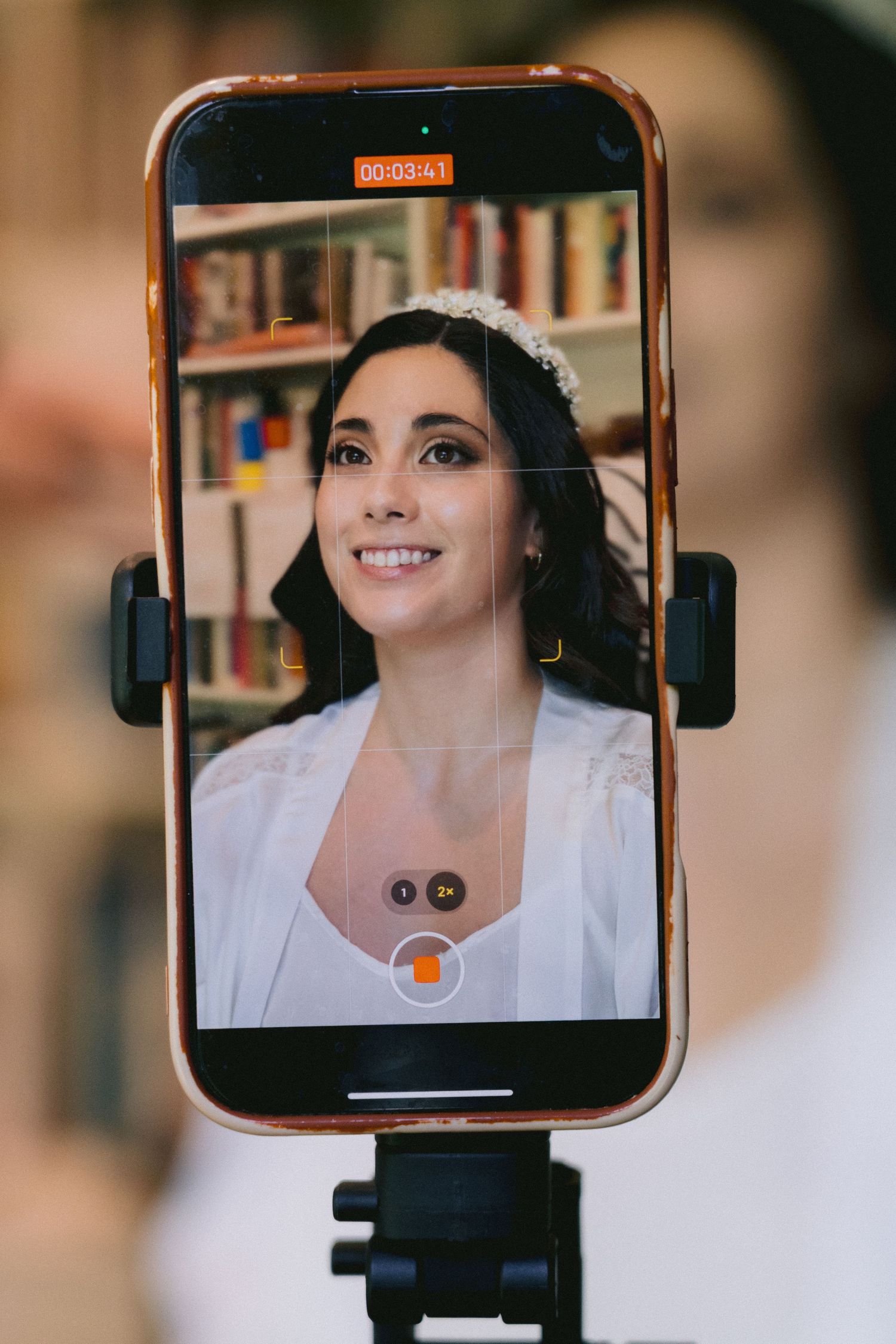 A video recording setup showing a phone mounted on a tripod displaying a close-up shot.