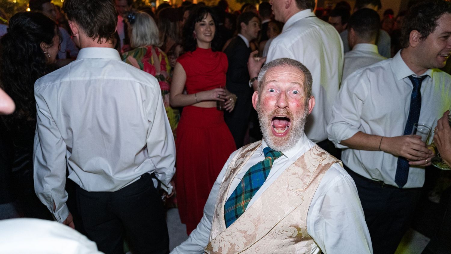 Guests celebrating and dancing at an energetic indoor reception party.
