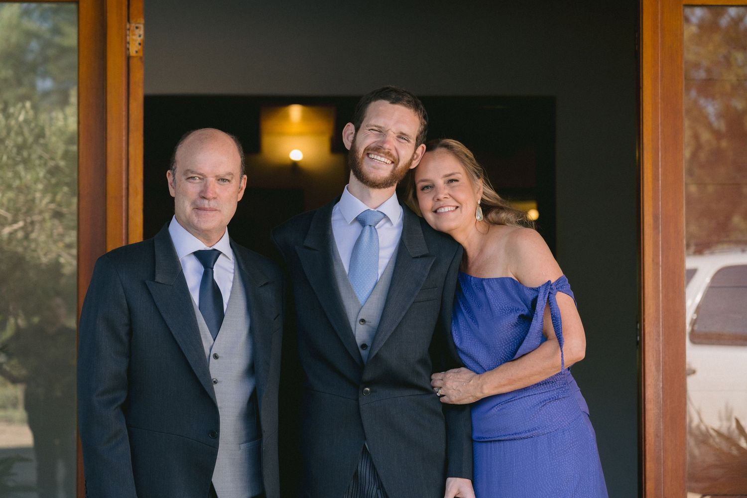 Wedding party members posing together in formal attire.