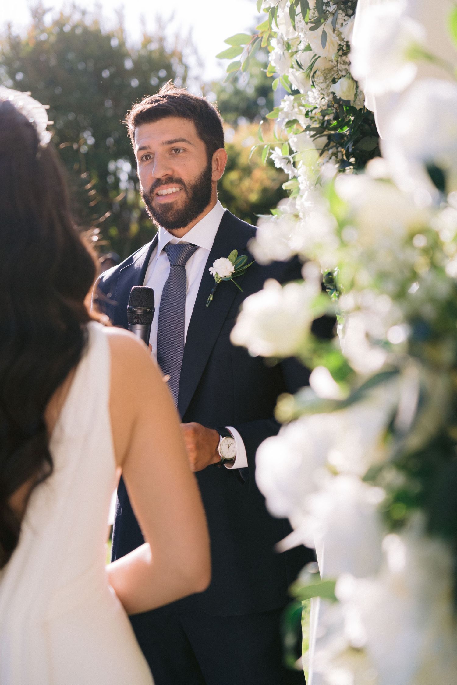 Intimate wedding ceremony moment framed by white floral decorations.