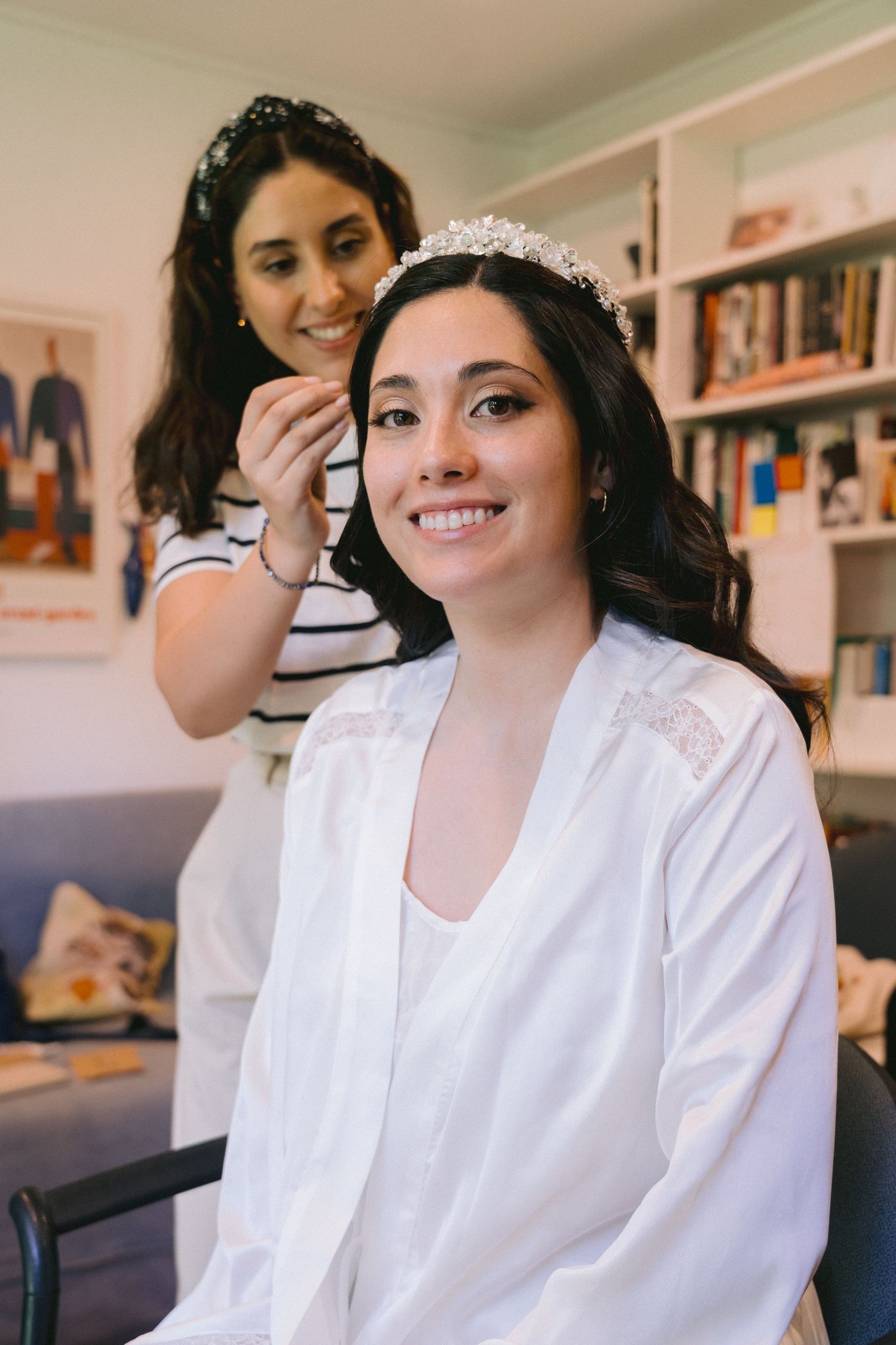 Wedding preparation scene in a cozy room with bookshelves in the background.