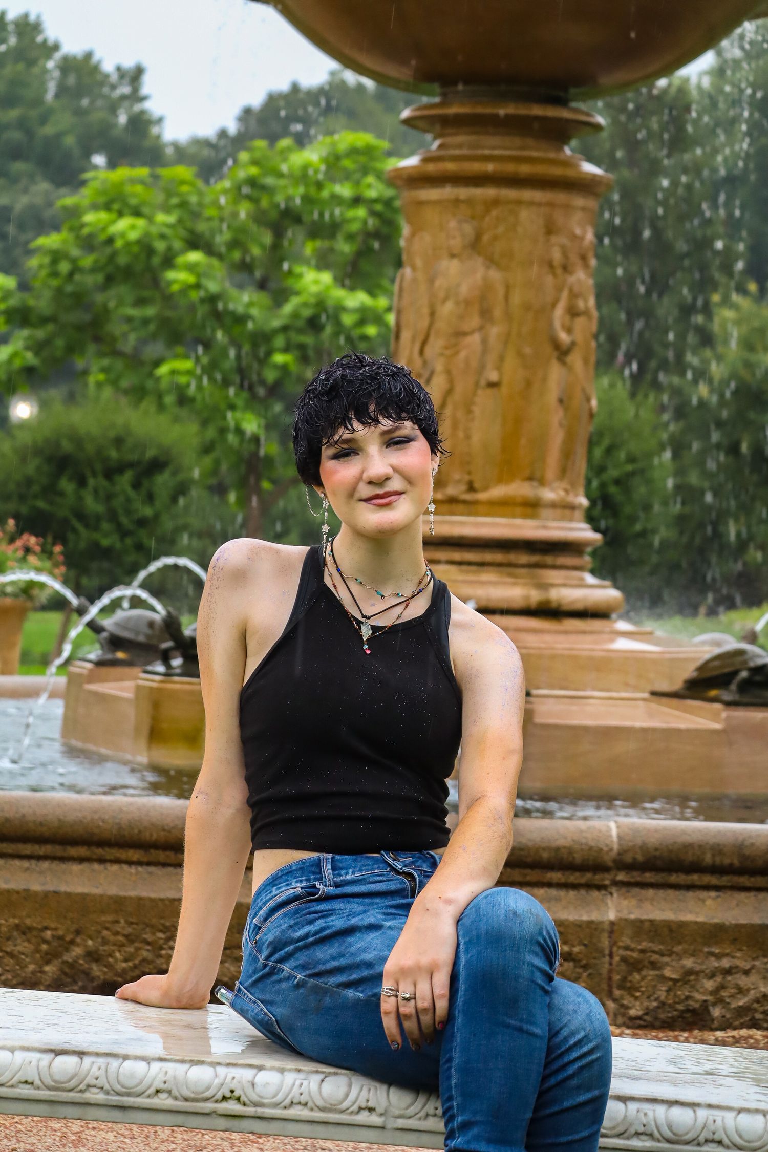 Senior portrait. Rainy, garden, fountain.