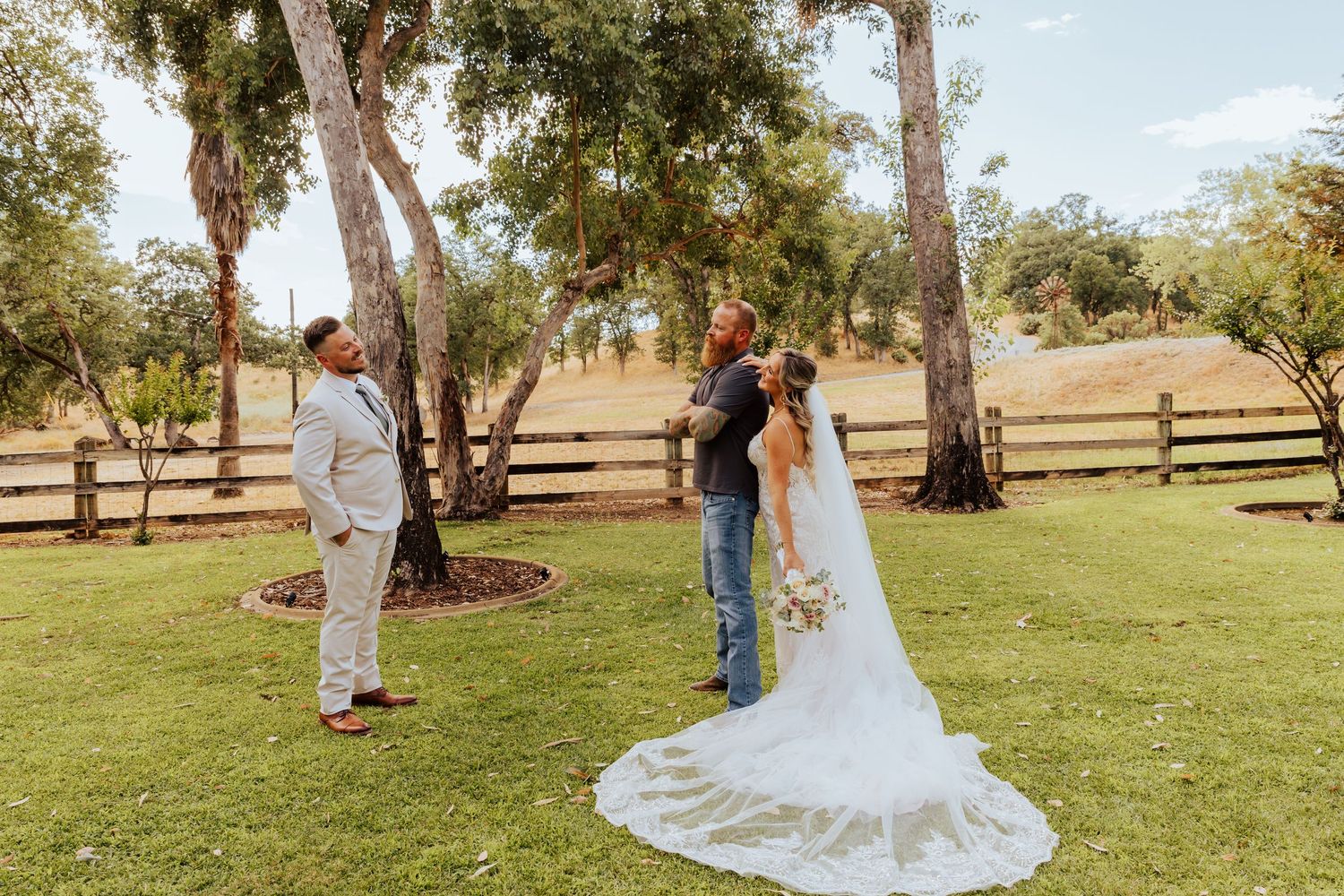 Scenic outdoor wedding portraits with rolling hills and trees in the background.