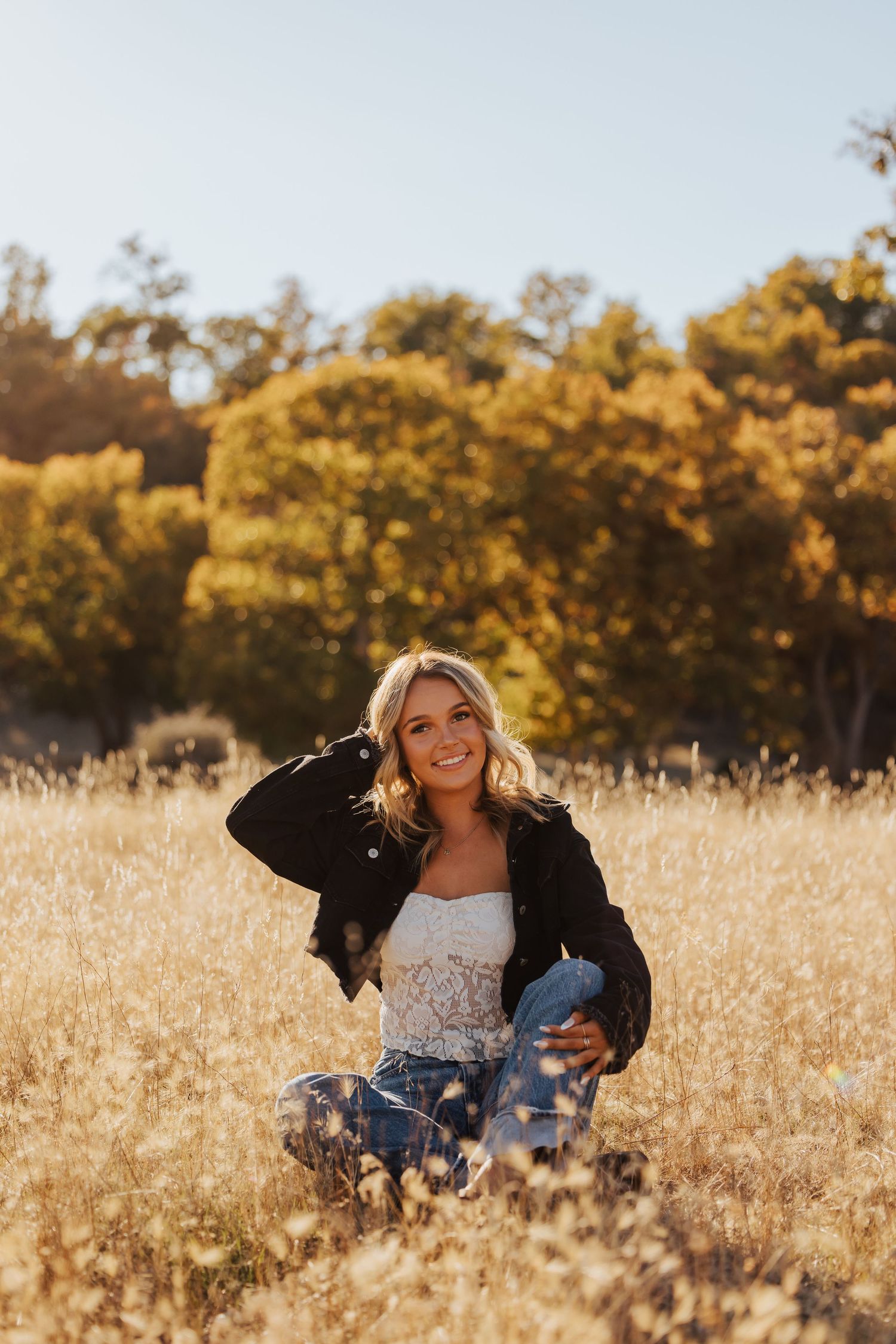 Relaxed outdoor portraits in tall grass with warm autumn lighting.