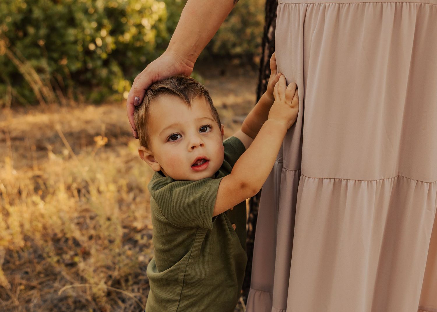 Candid family interactions captured against soft natural lighting in outdoor setting.