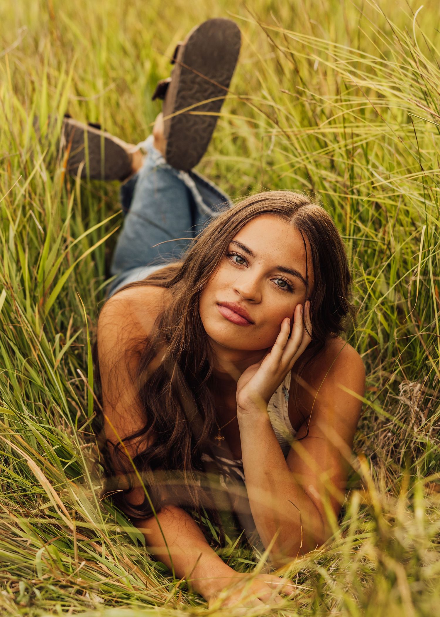 Summer portrait in tall grass with natural lighting and earth tones.