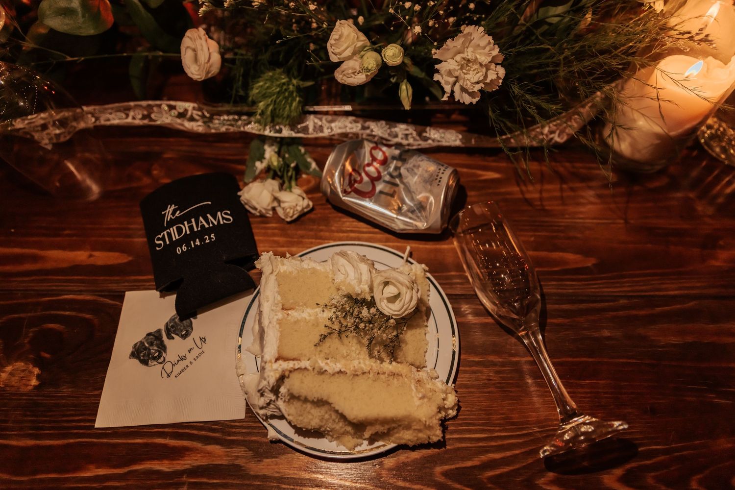 Rustic wooden table decorated with wedding details and warm lighting.