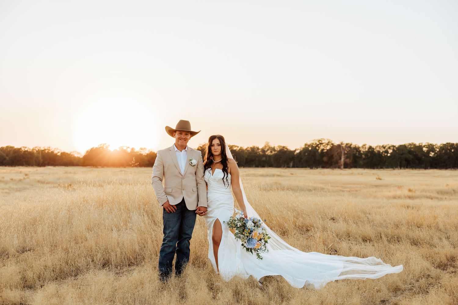 Romantic sunset wedding photography session in a rustic field with golden light.