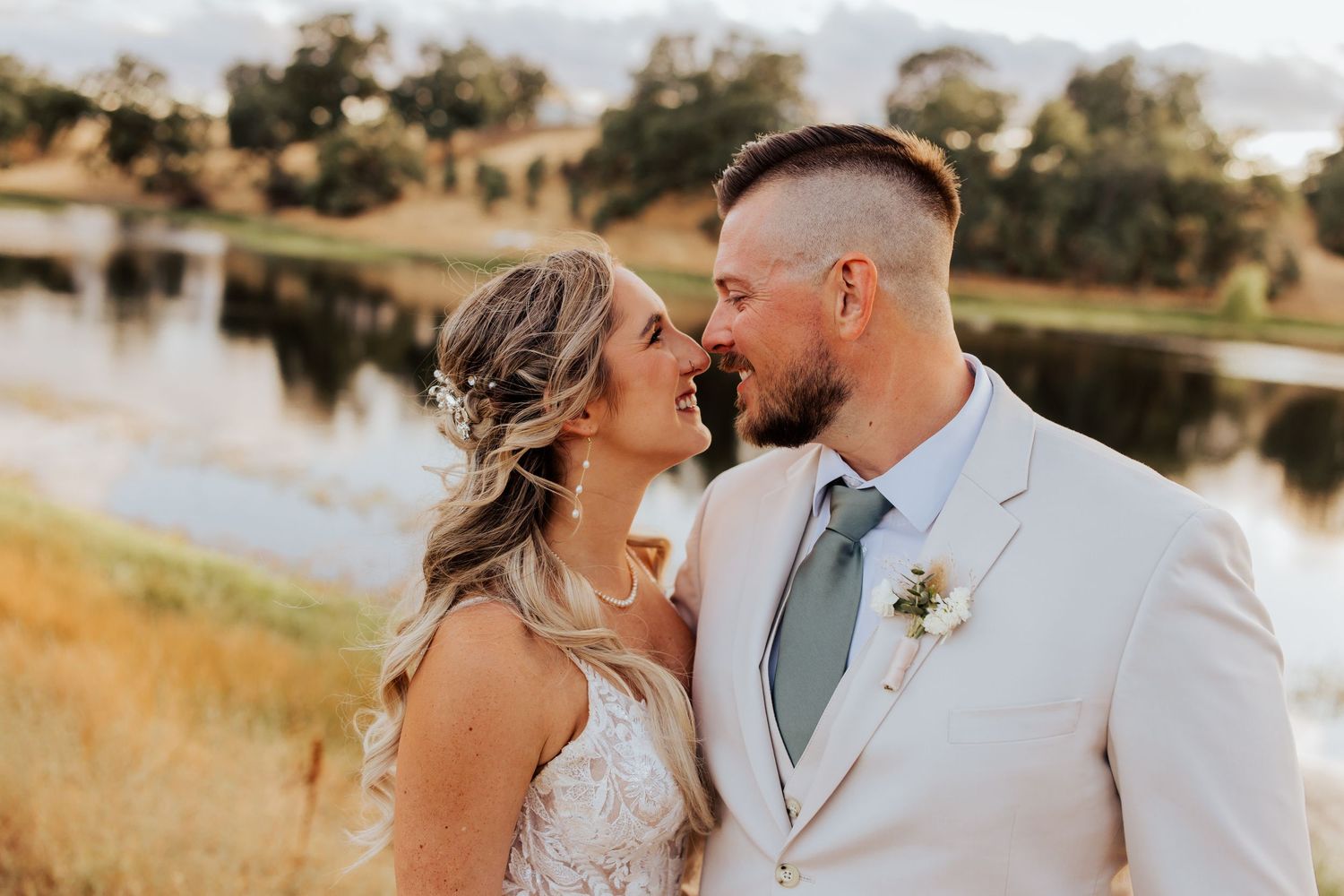 Romantic lakeside wedding portraits captured during golden hour with natural landscape.