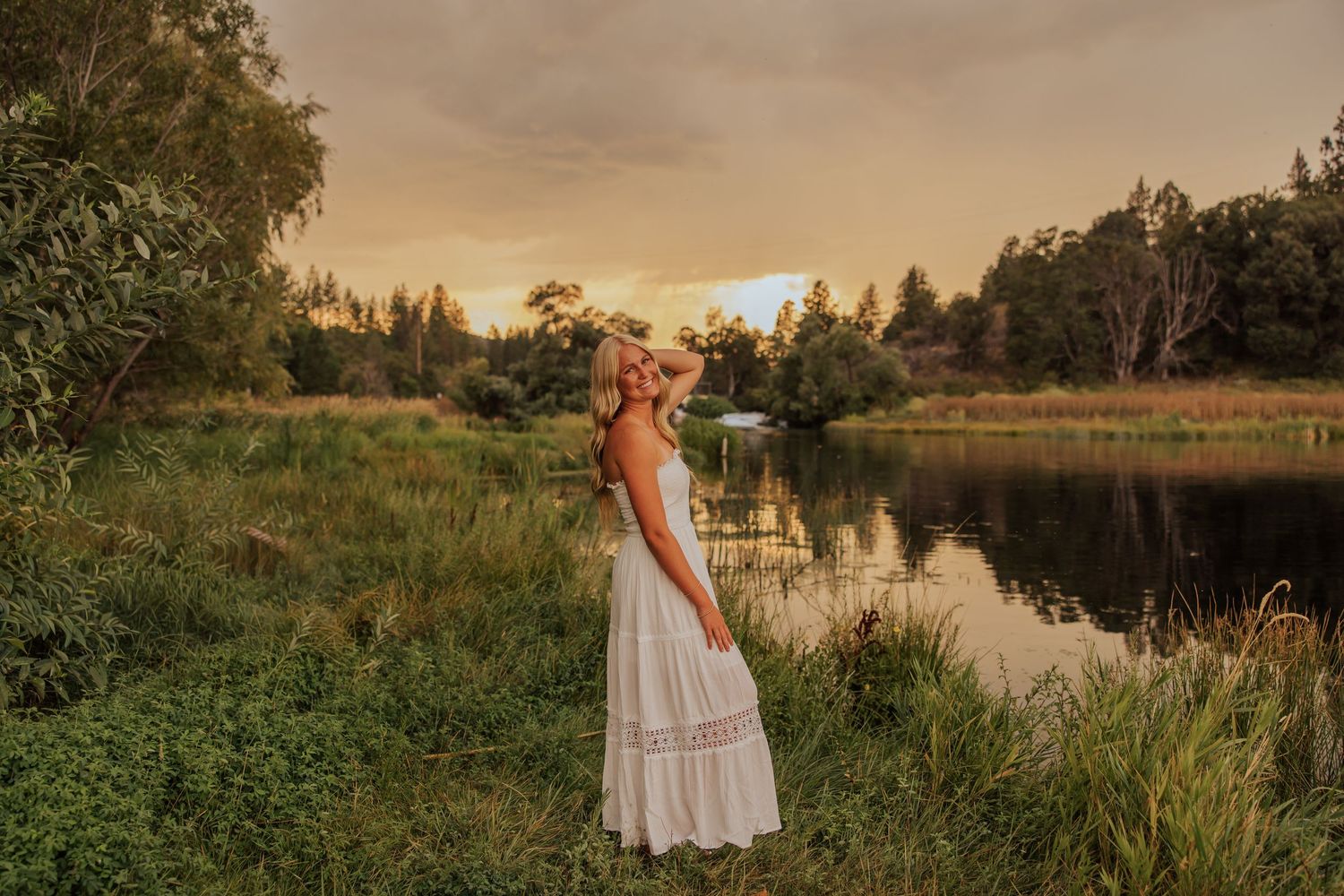 Person in white dress walking through natural landscape at golden hour.