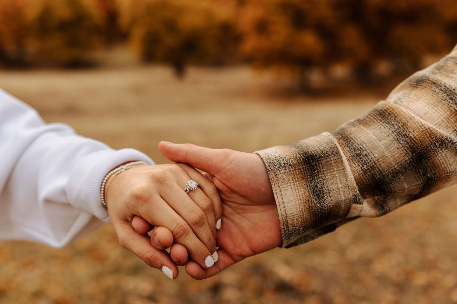 Detail shots of hands holding during an autumn engagement photoshoot.