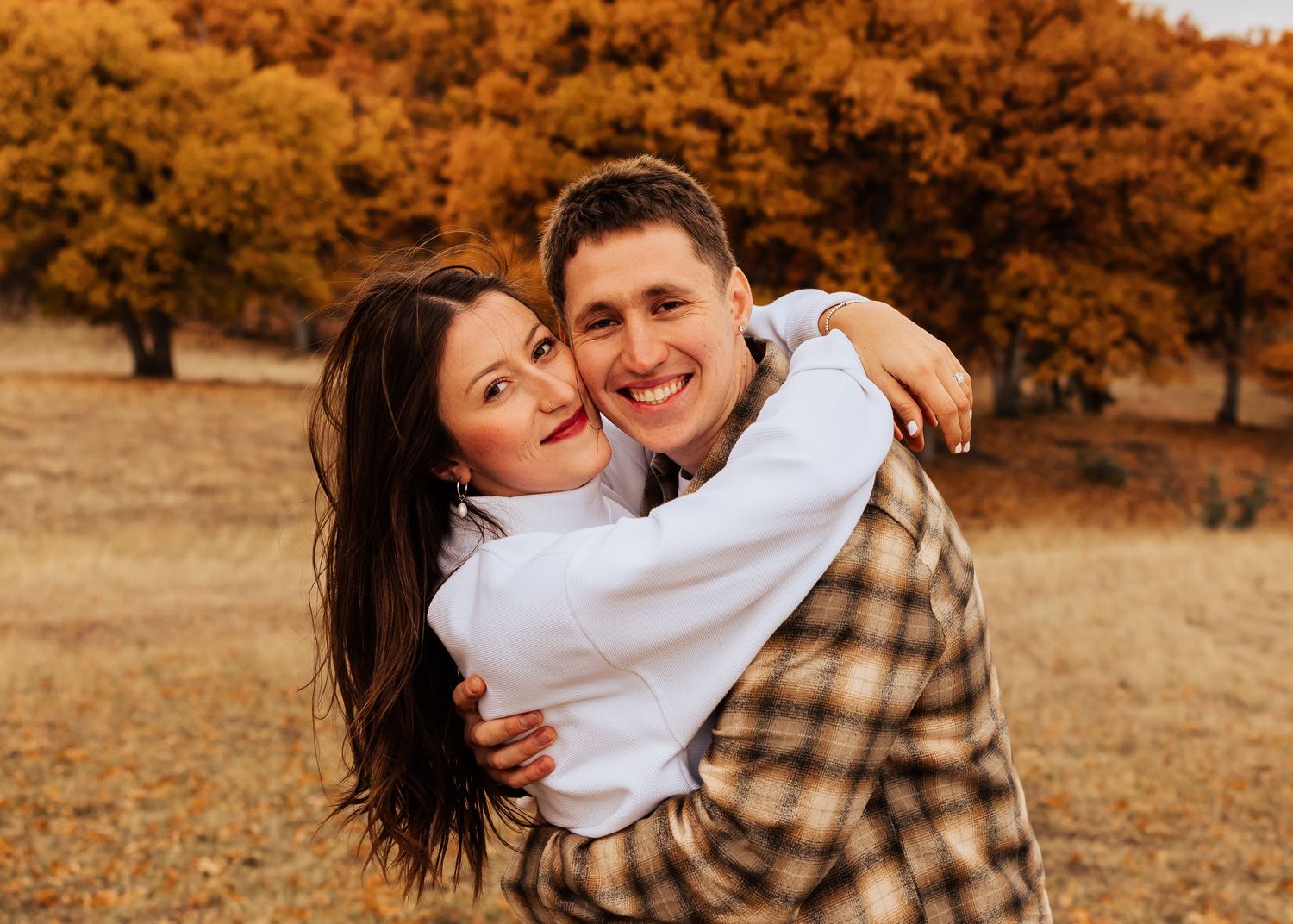 Candid moments of affection photographed during a fall outdoor photoshoot.
