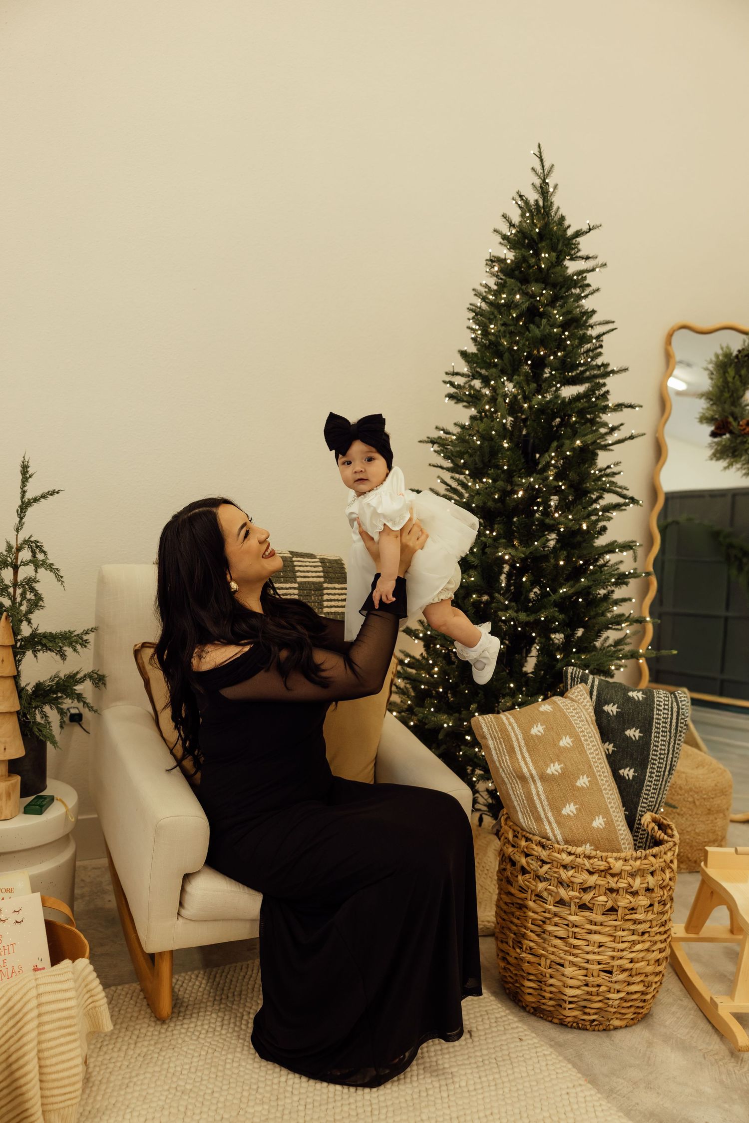 A festive scene with Christmas trees and woven baskets in a bright, minimalist studio setting.