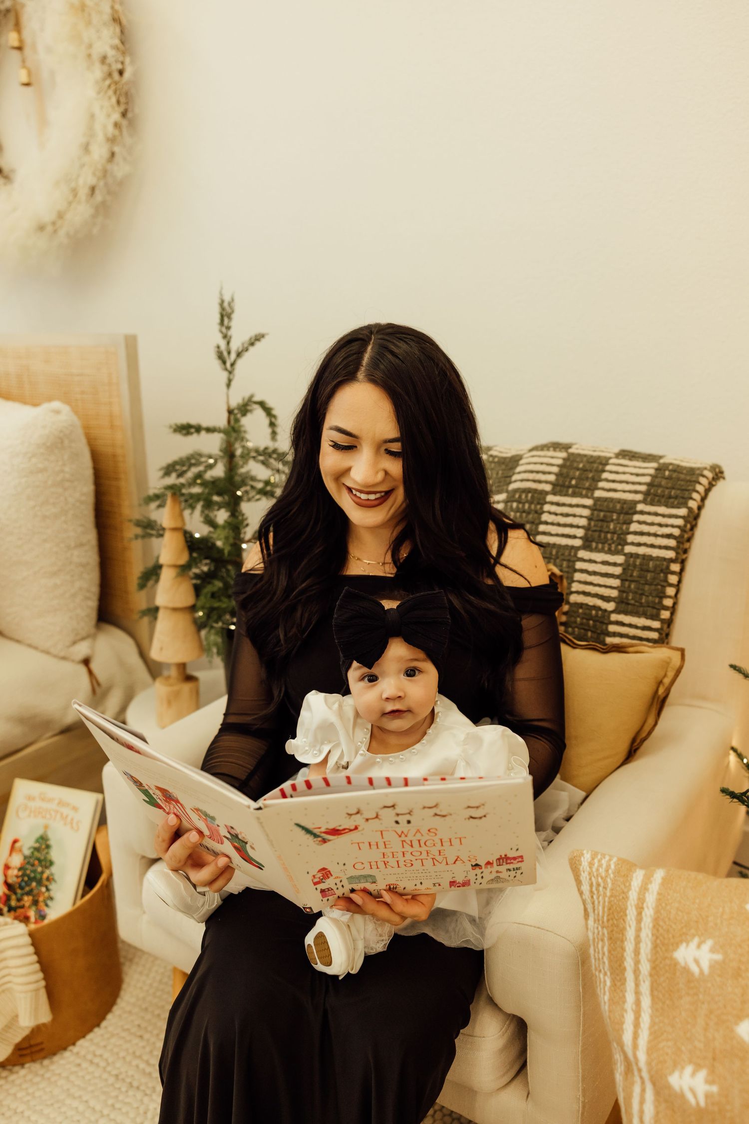 Two people share a joyful moment reading a book together on a cozy couch with holiday decor.