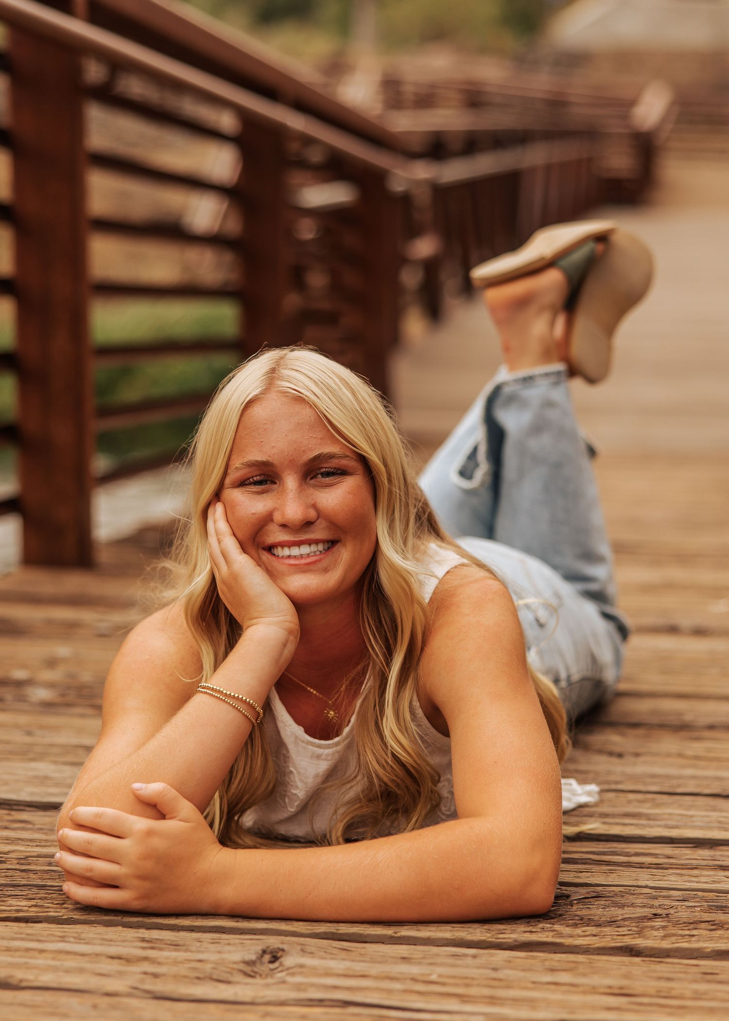 Casual lifestyle portrait lying on wooden deck with feet raised.