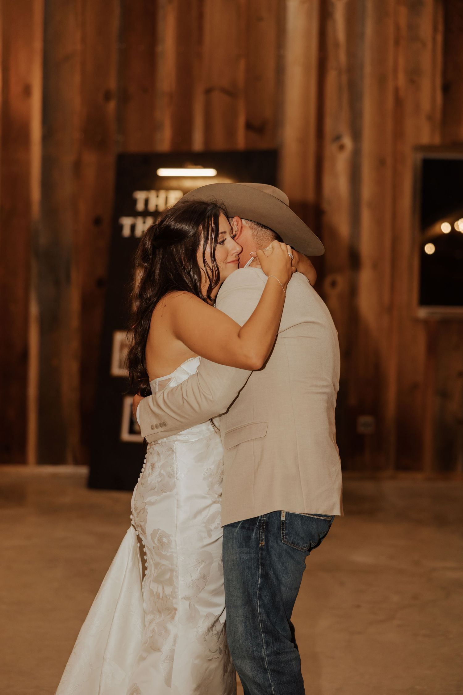 Romantic first dance sequence in a rustic wooden barn with warm lighting and draped fabric decor.