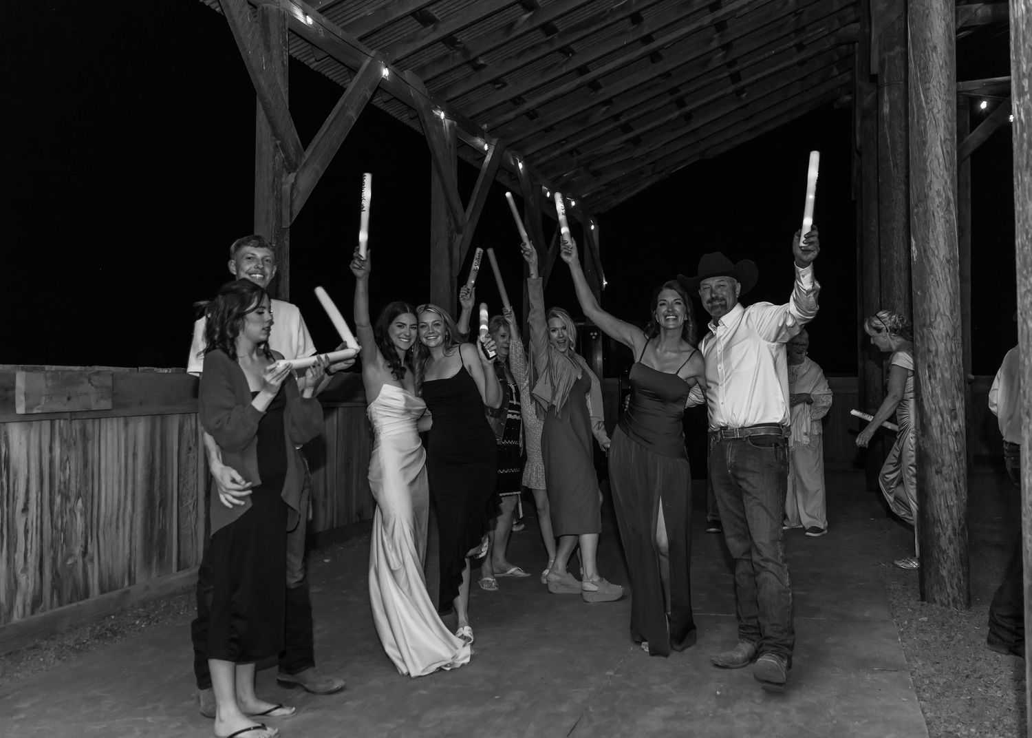 Wedding guests dancing and celebrating at a nighttime outdoor reception.