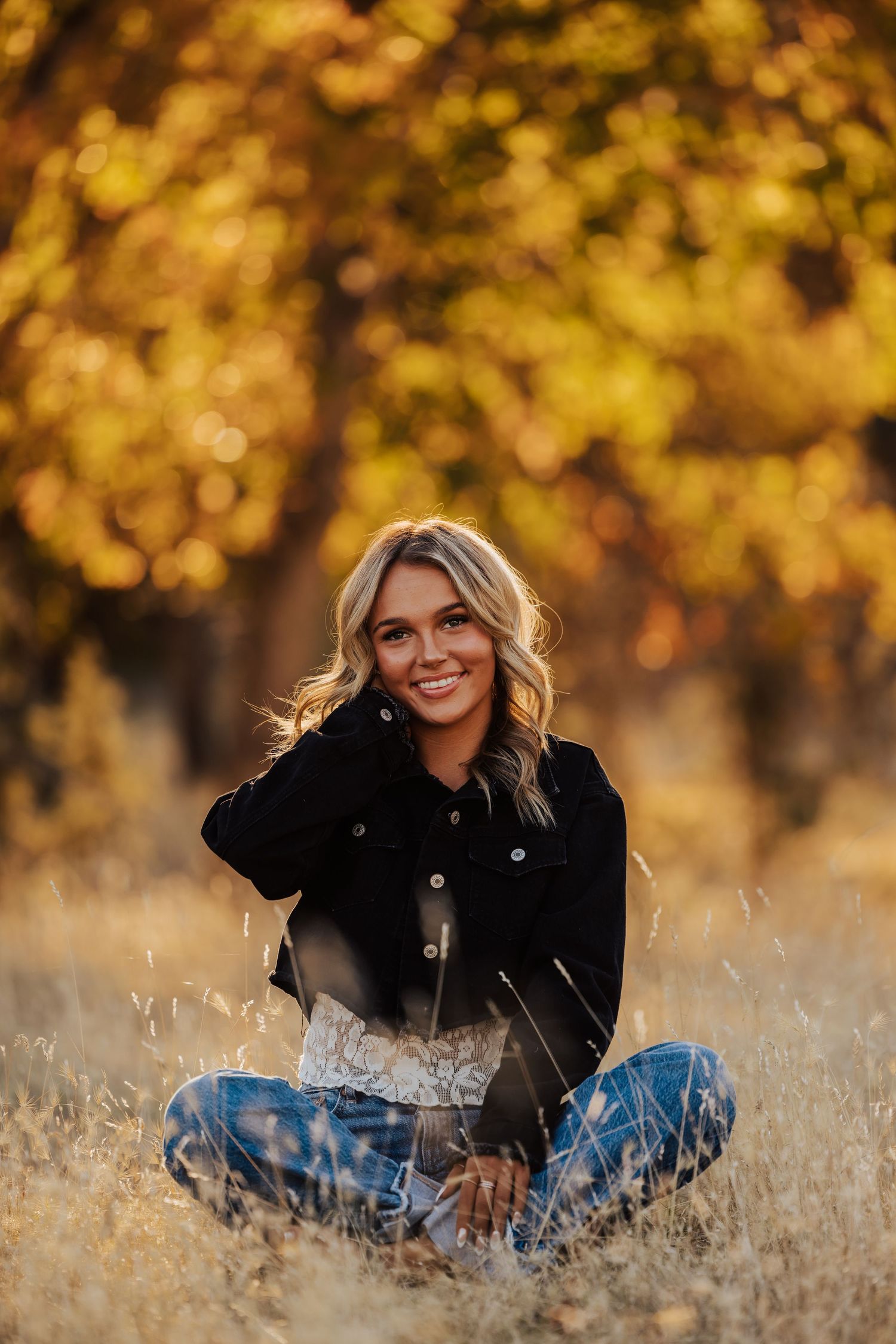 Relaxed outdoor portrait session with warm autumn colors and dried grass in the background.