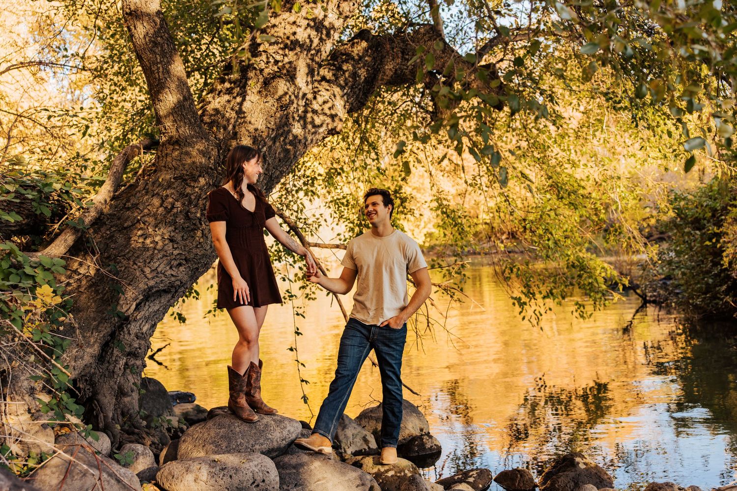 Scenic waterfront location with autumn trees and rocky shoreline at sunset.