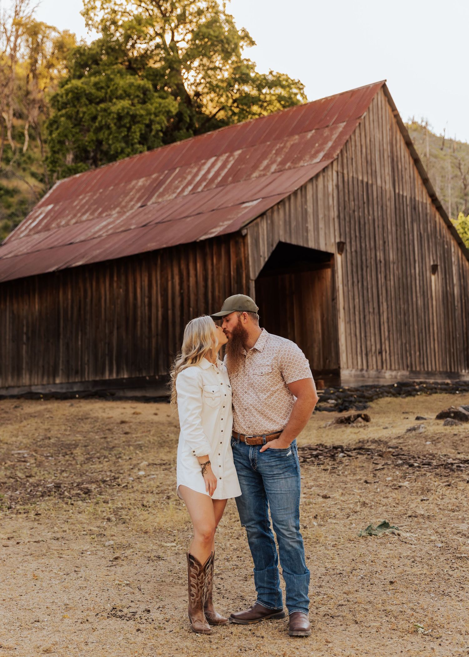 A romantic country photoshoot featuring a rustic barn and natural outdoor setting.