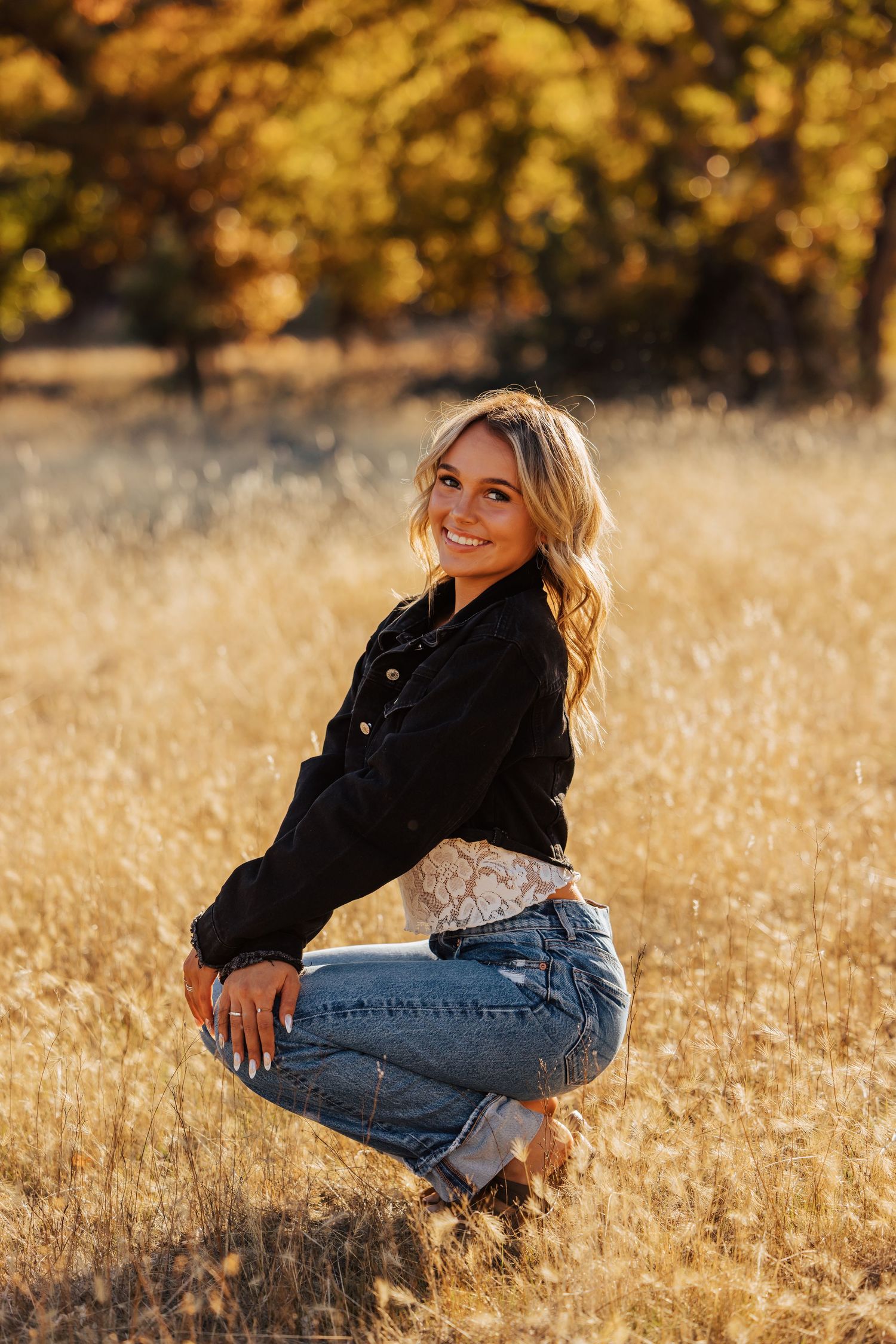 A casual autumn portrait session in a field with warm sunset lighting and fall colors.