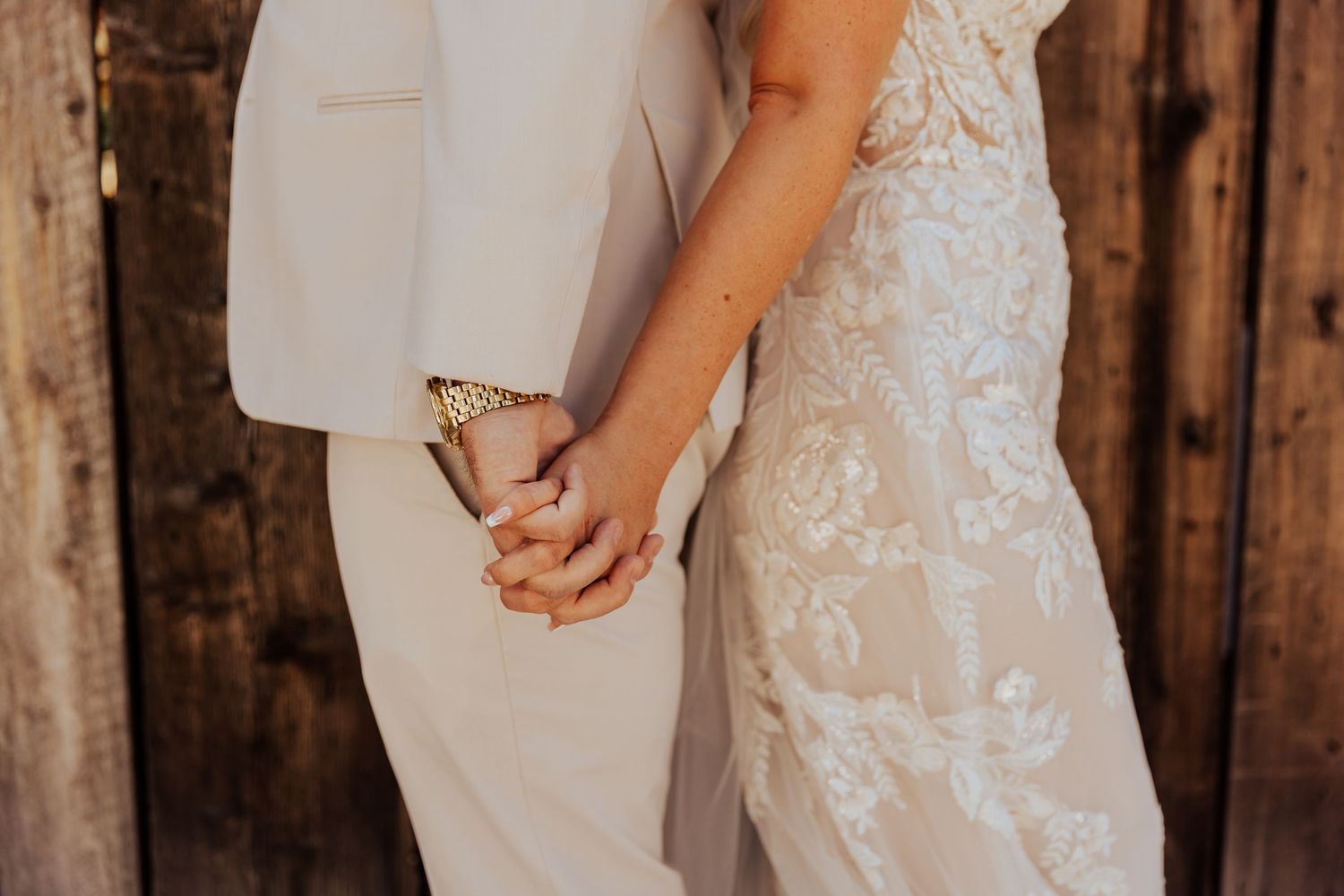 Wedding couple sharing intimate moment in front of rustic wooden barn wall.