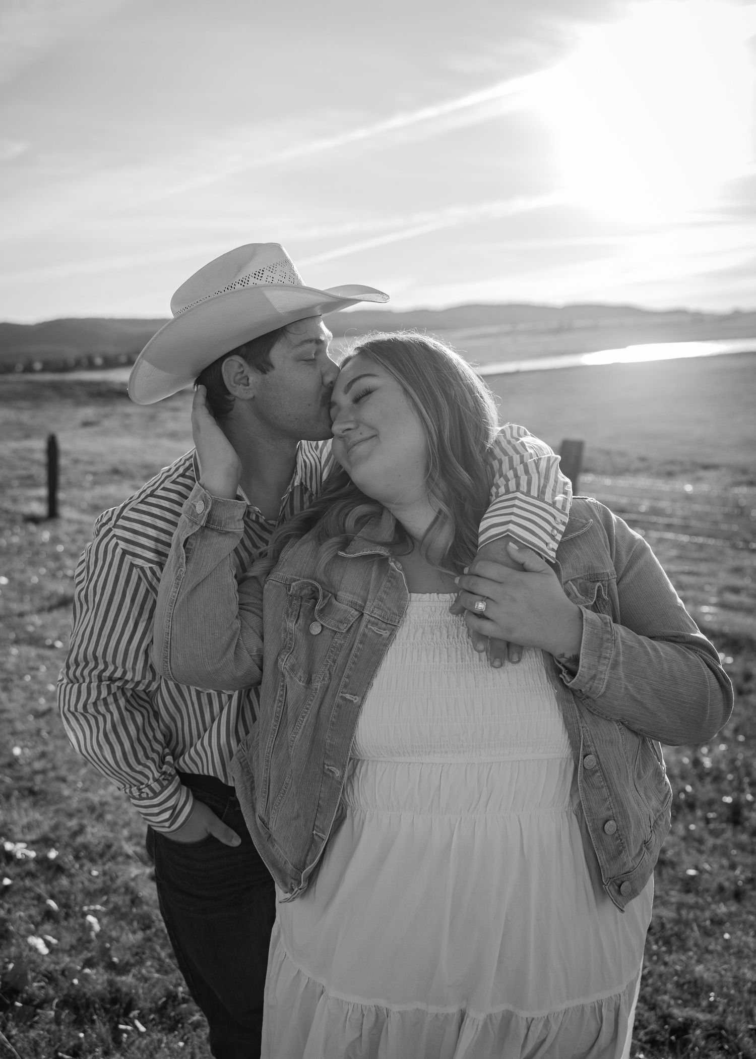 A romantic black and white photoshoot in a rustic countryside setting with a barn in the background.