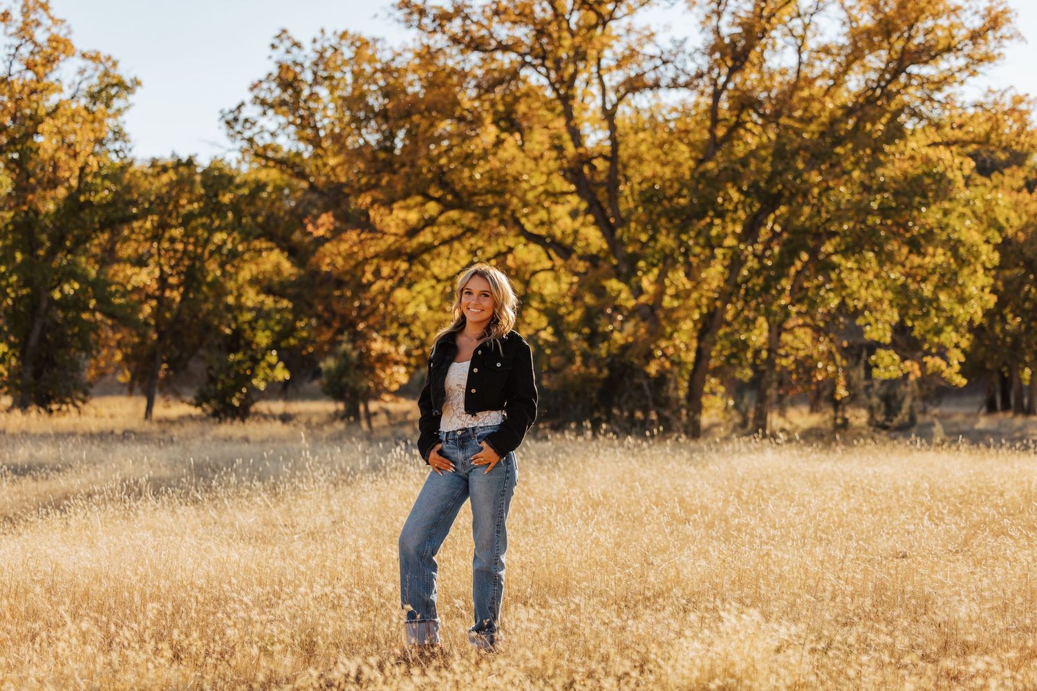 Golden autumn trees frame a casual outdoor portrait session.