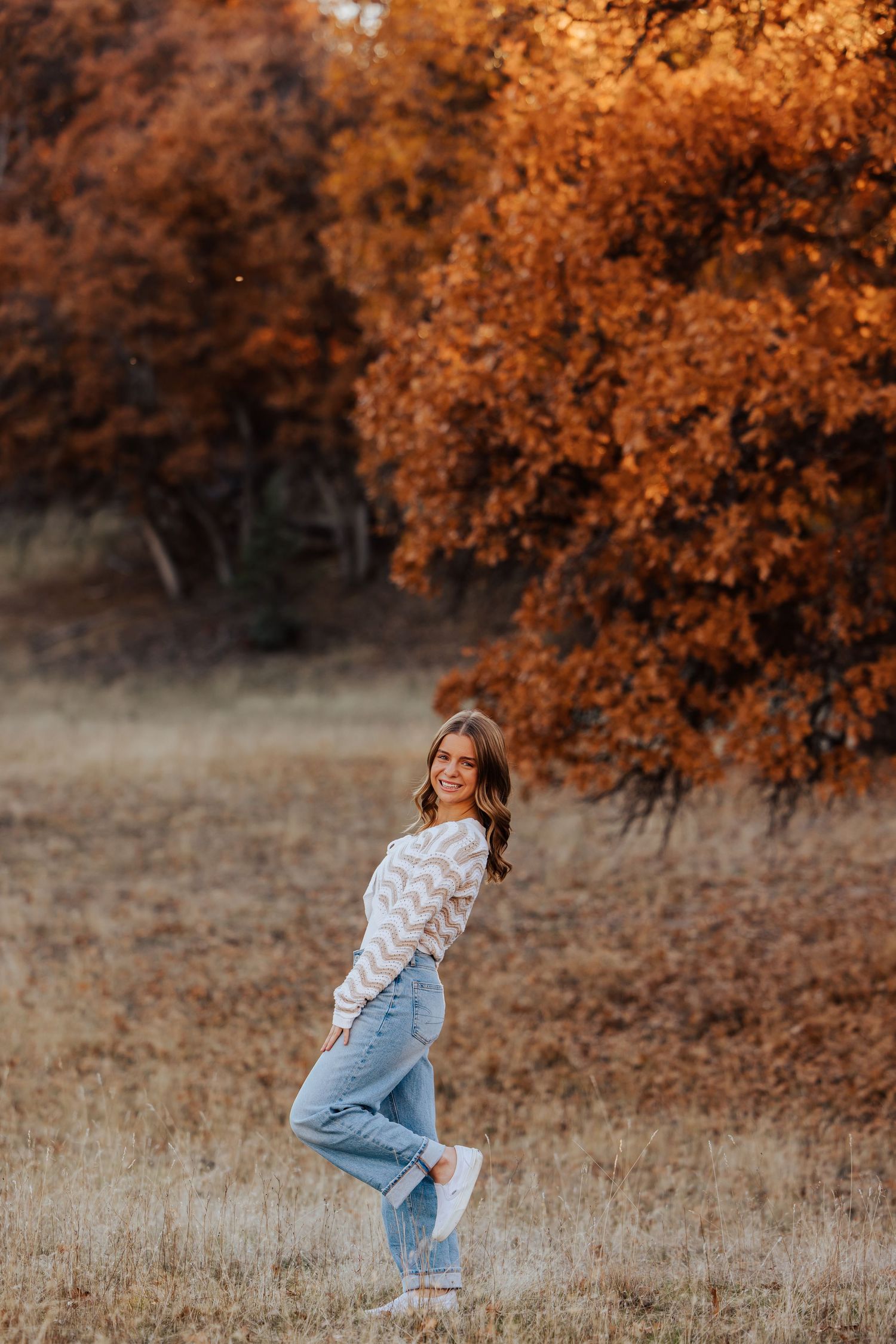 Energetic poses captured in a field with autumn colors and natural lighting.