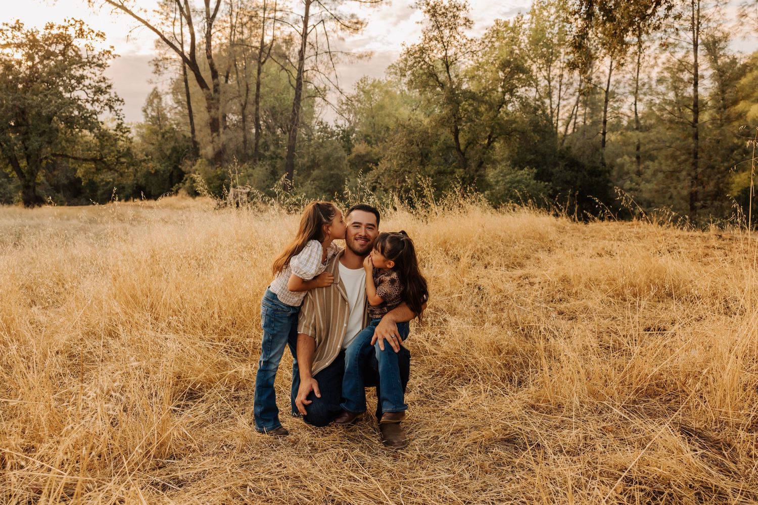 Family enjoying a warm autumn day in a field of tall golden grass.