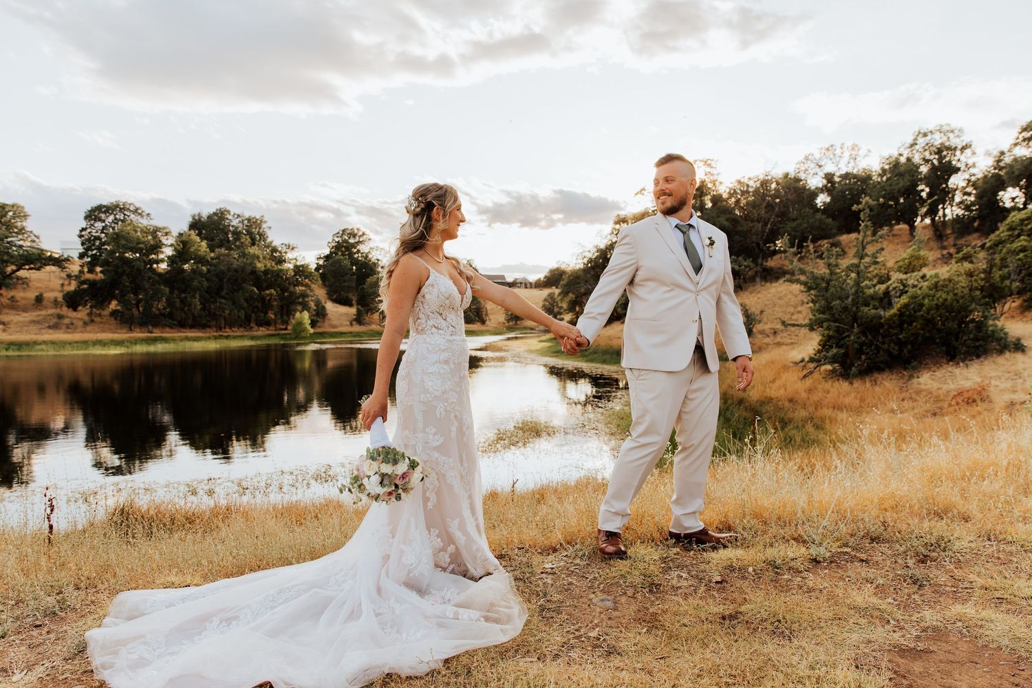 Wedding couple shares intimate moments during lakeside photo session at sunset.