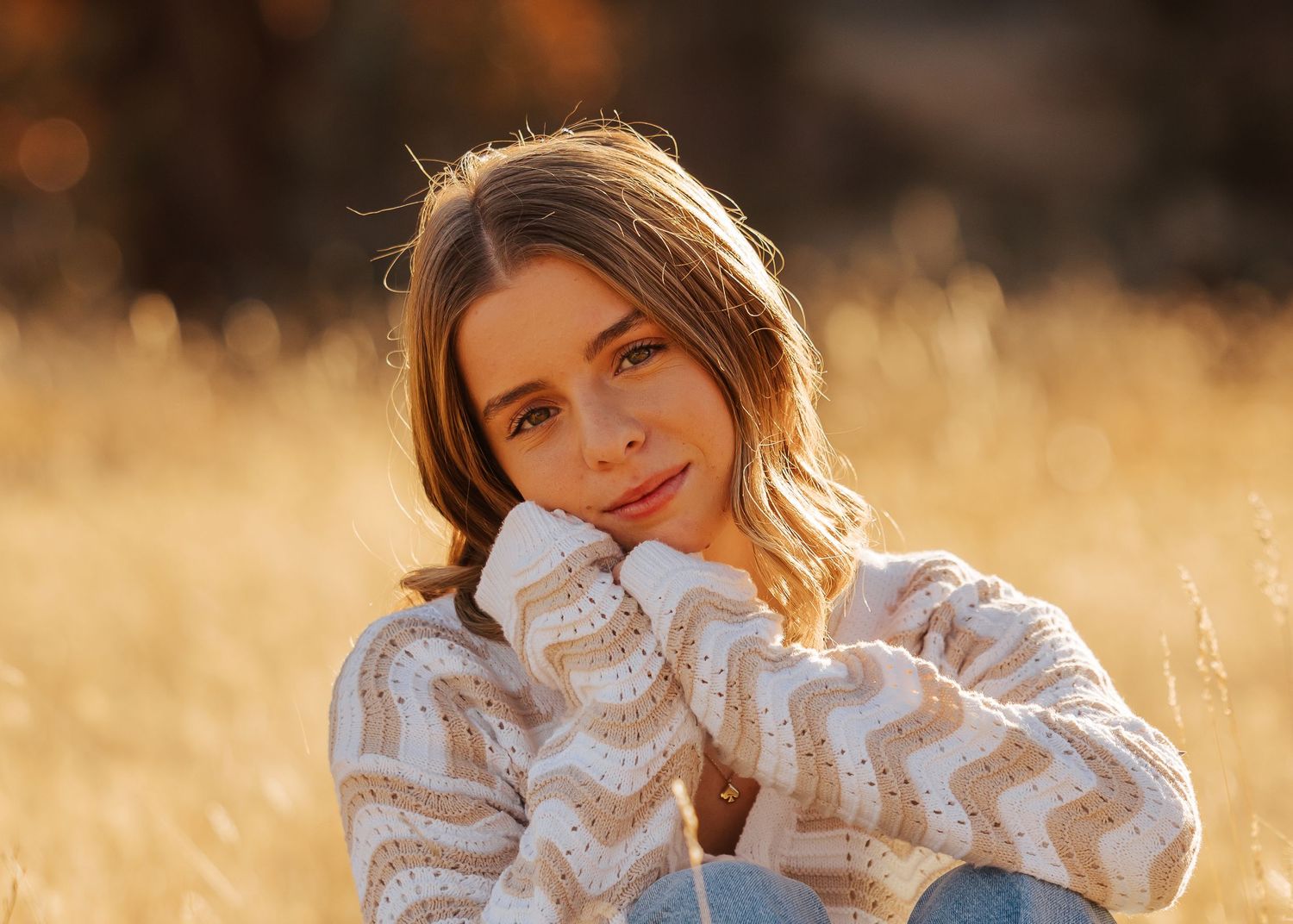 Candid autumn portraits in a field with soft lighting and a white lace top.