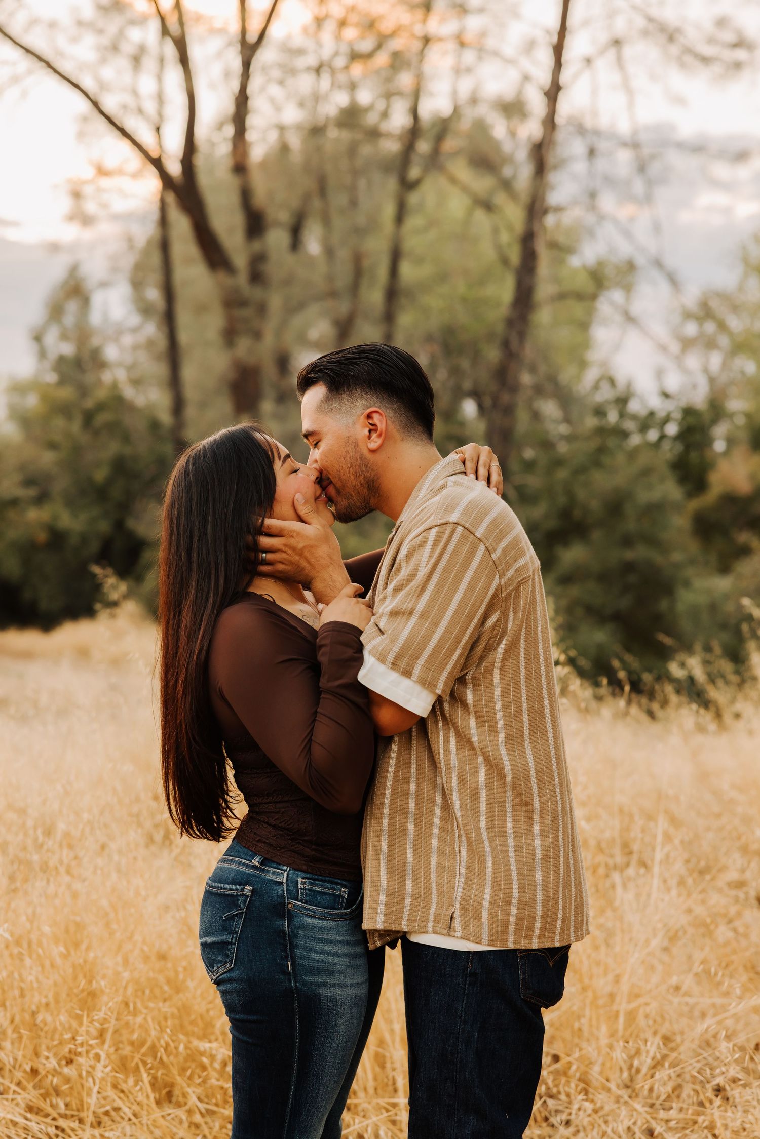 Intimate couple portrait in a golden field with warm autumn lighting.