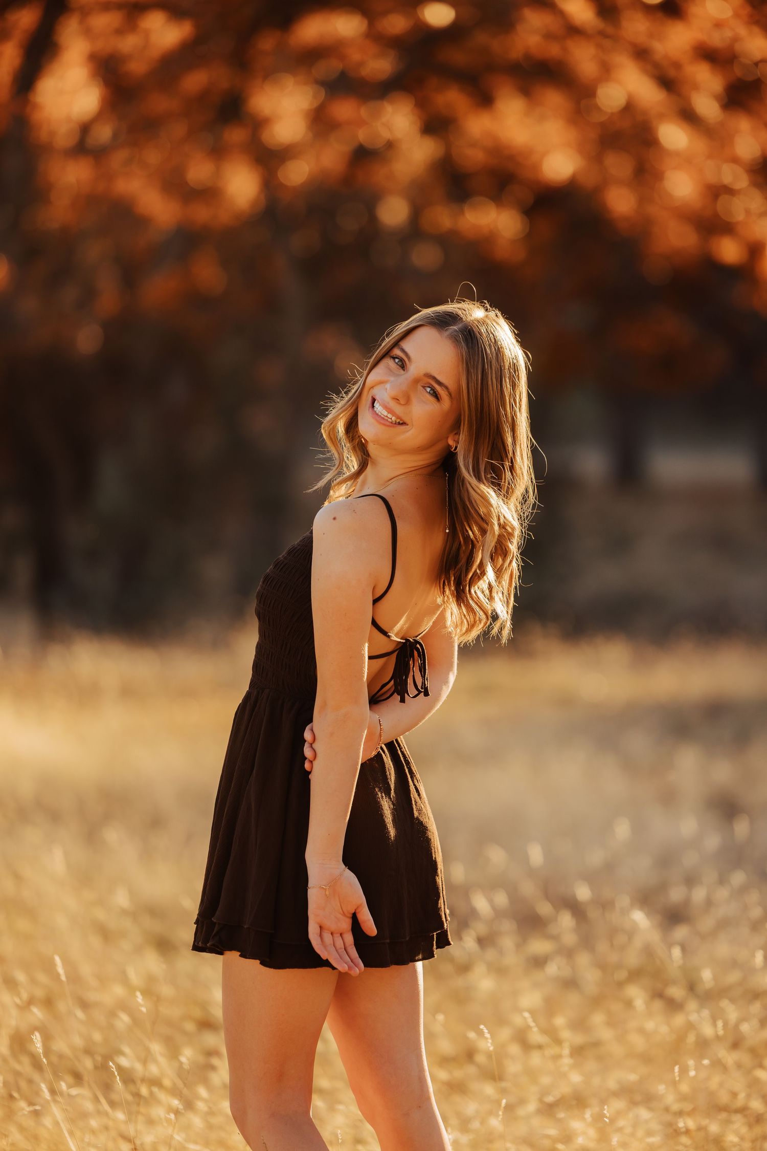 Artistic sunset portraits in a black dress with golden autumn lighting.