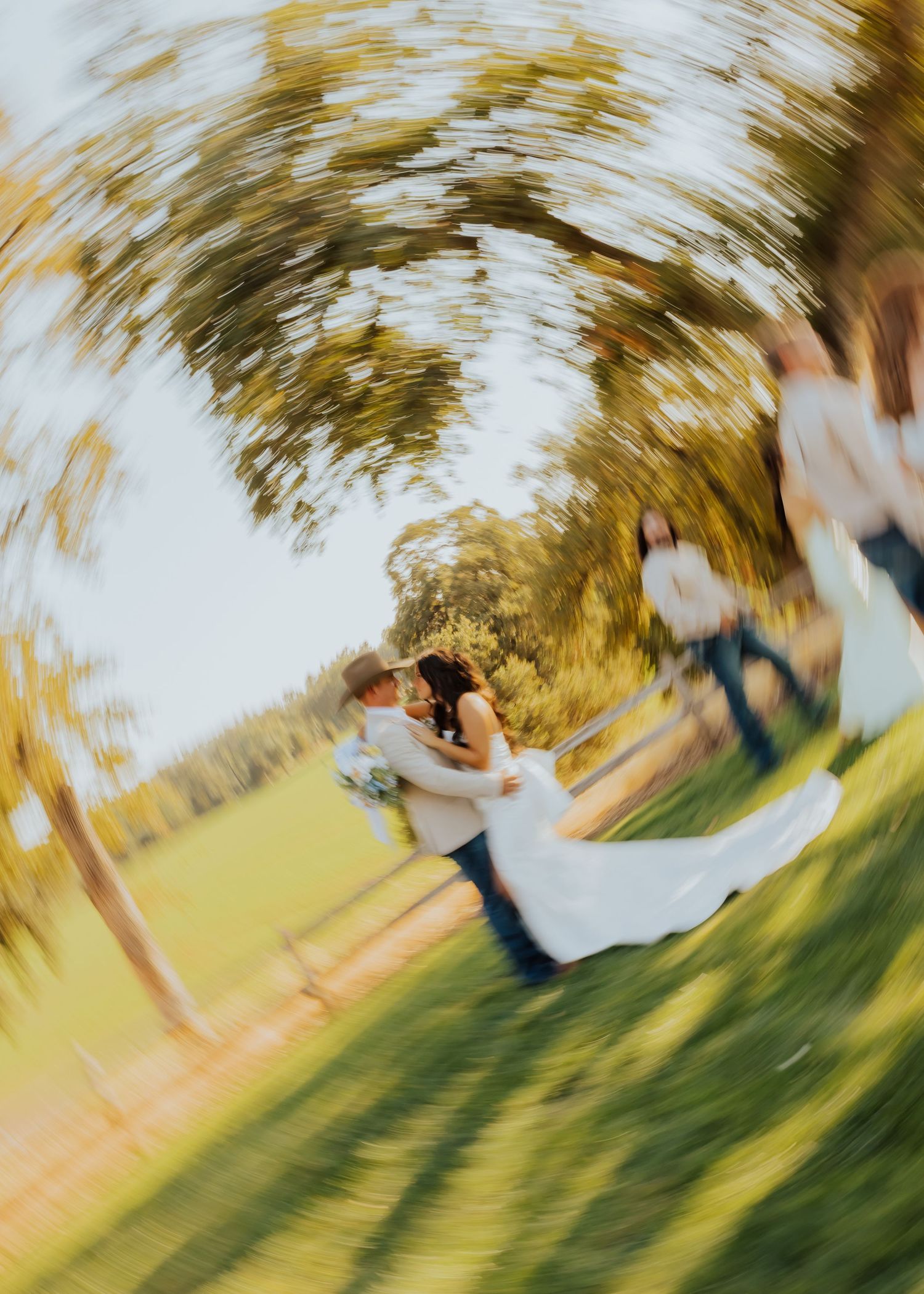 Artistic spinning motion blur photo of wedding couple in outdoor setting.